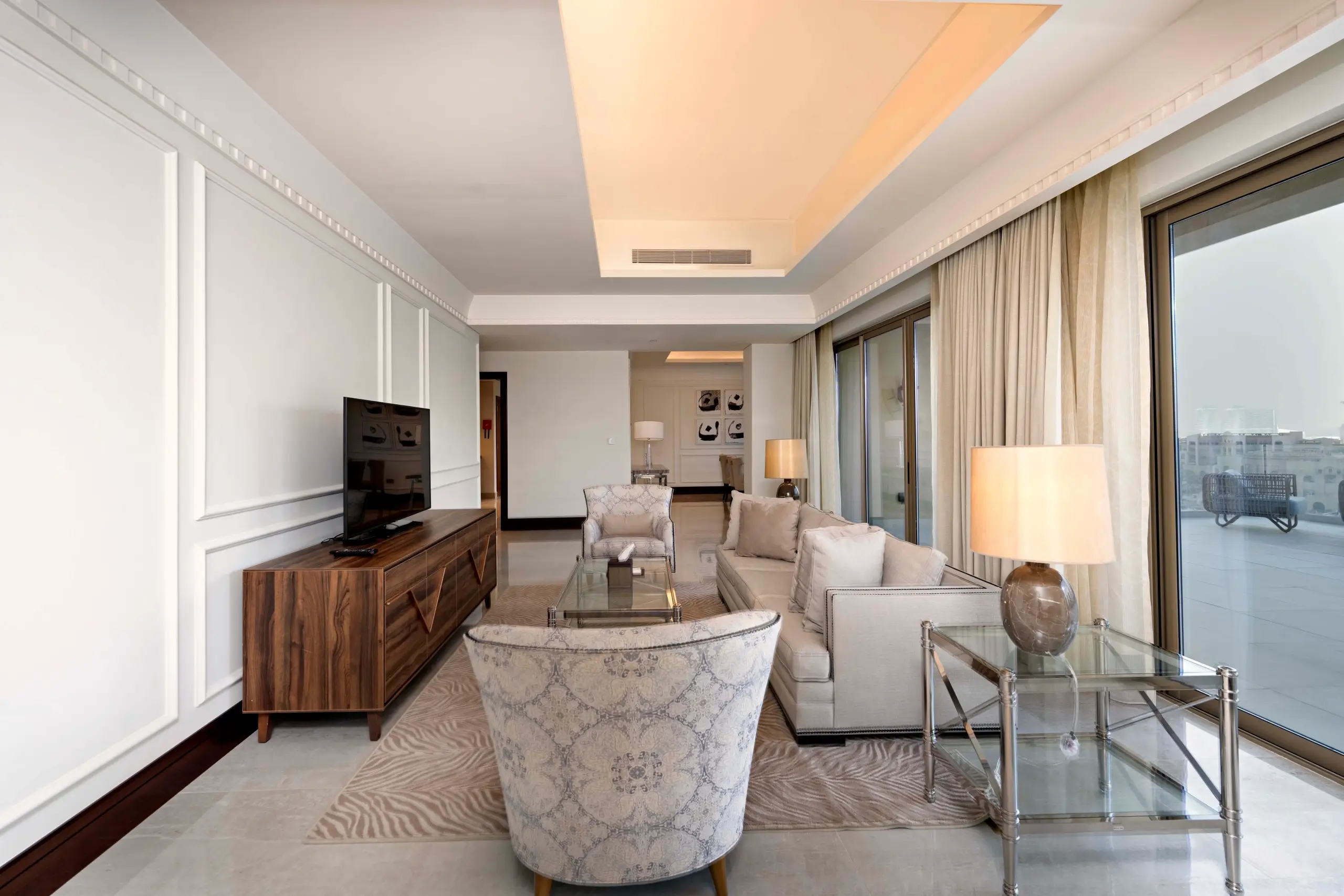 A stylish living room with a large TV and balcony.