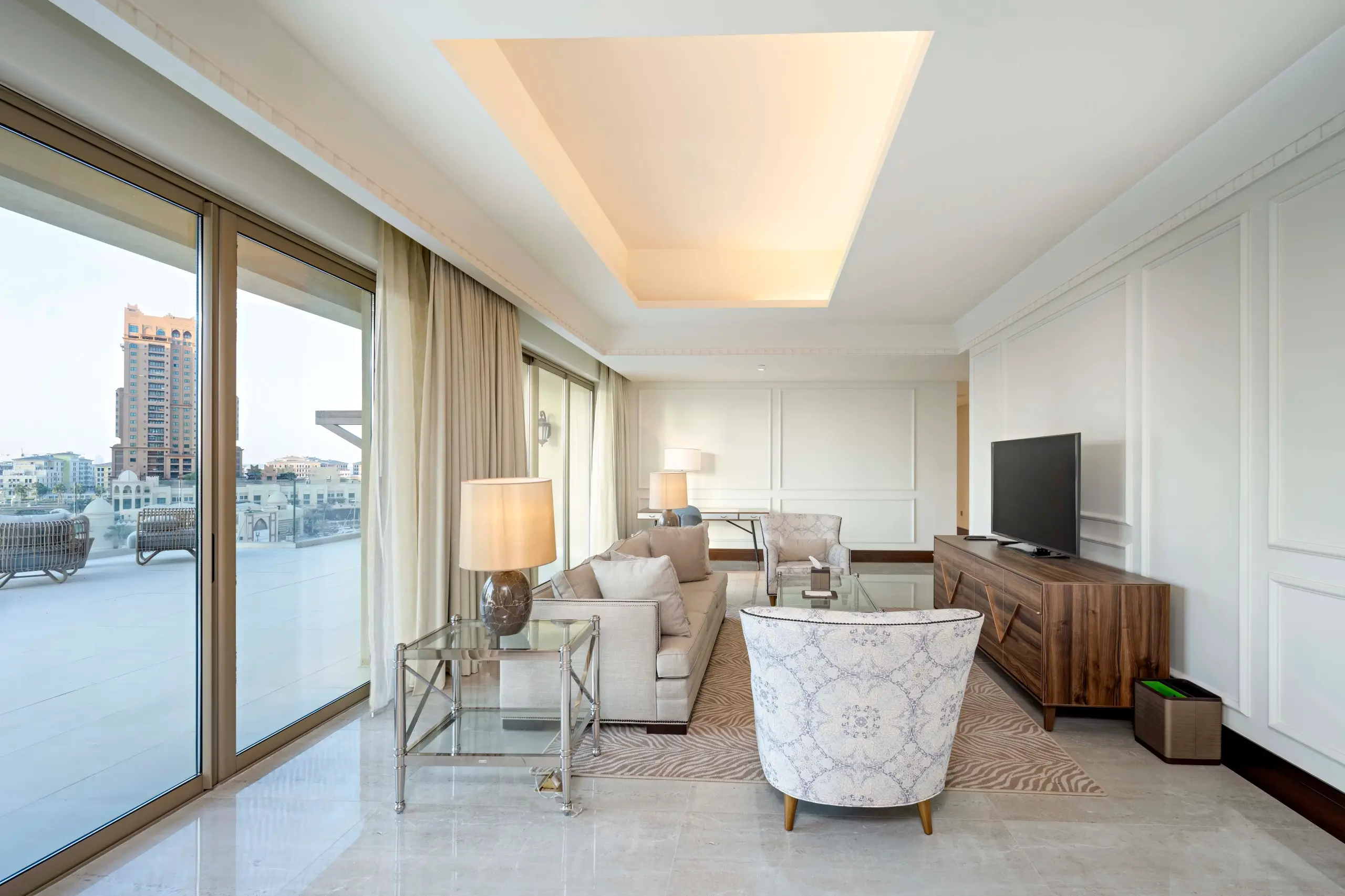 A modern living room with a large TV and balcony.