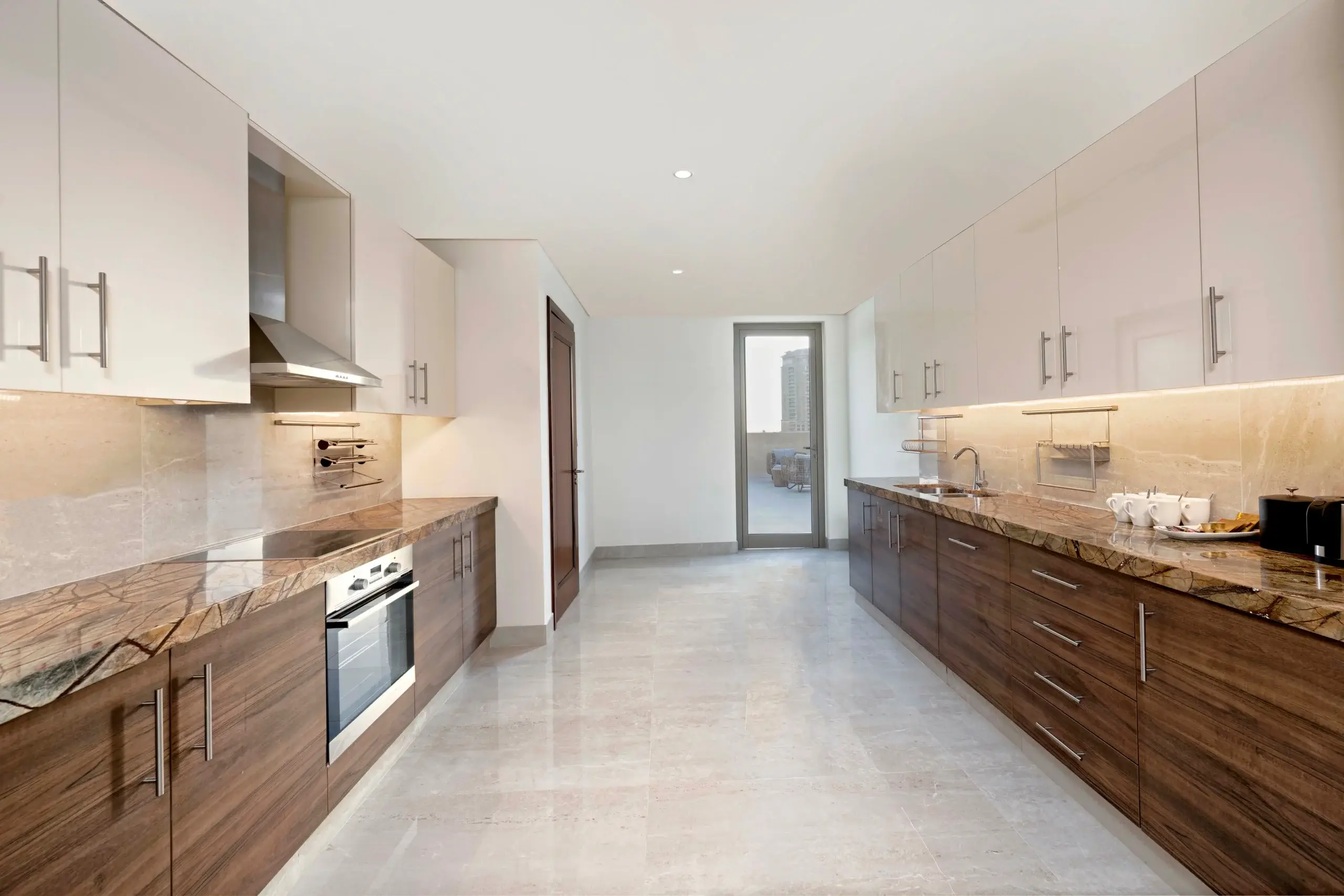 A modern kitchen with wood cabinets and marble counters.