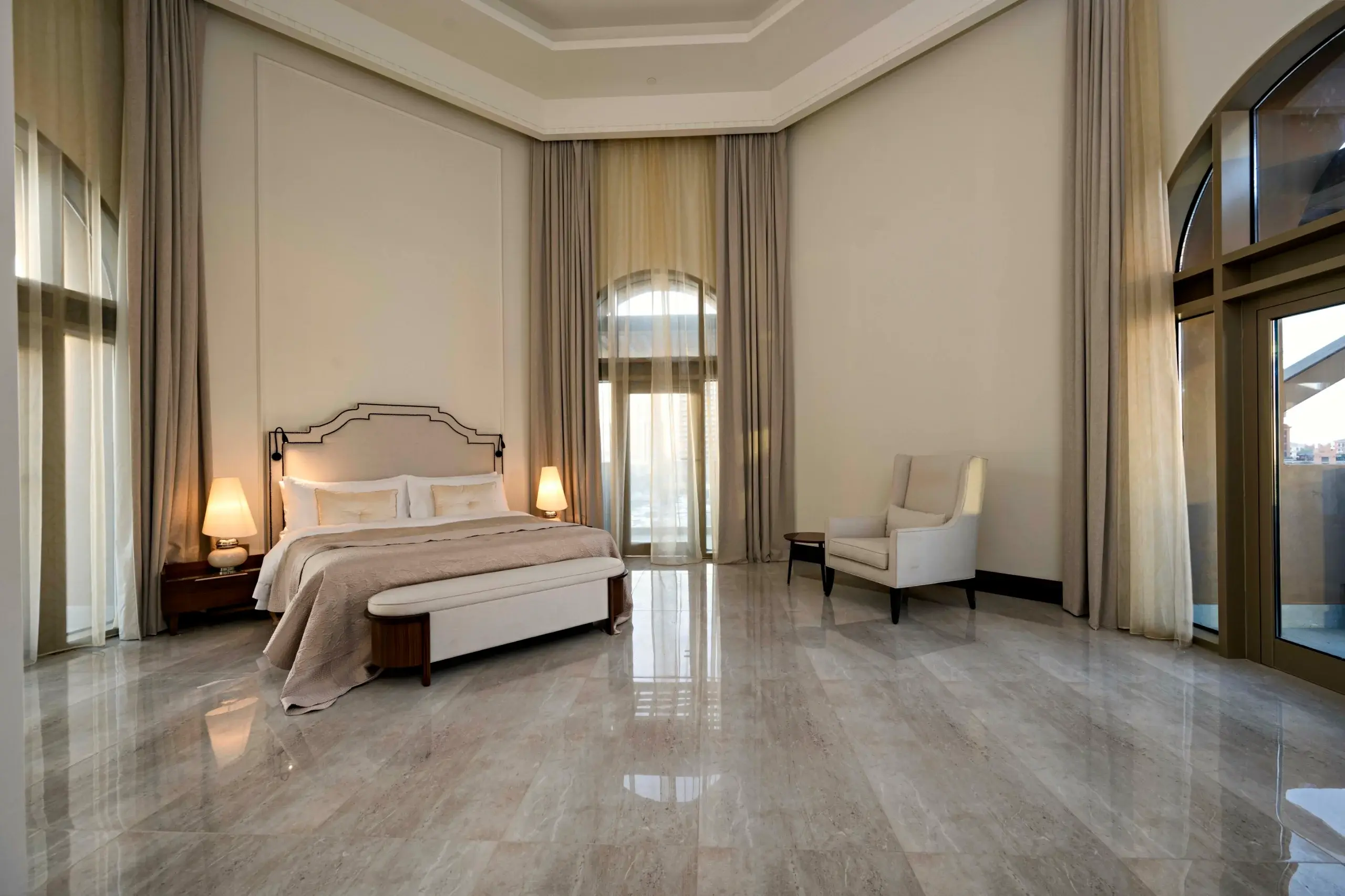 A lavish bedroom with a large bed and arched window.