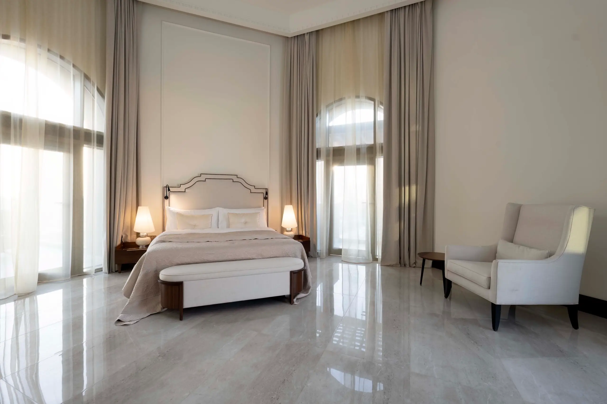 A large, elegant bedroom with high ceilings.