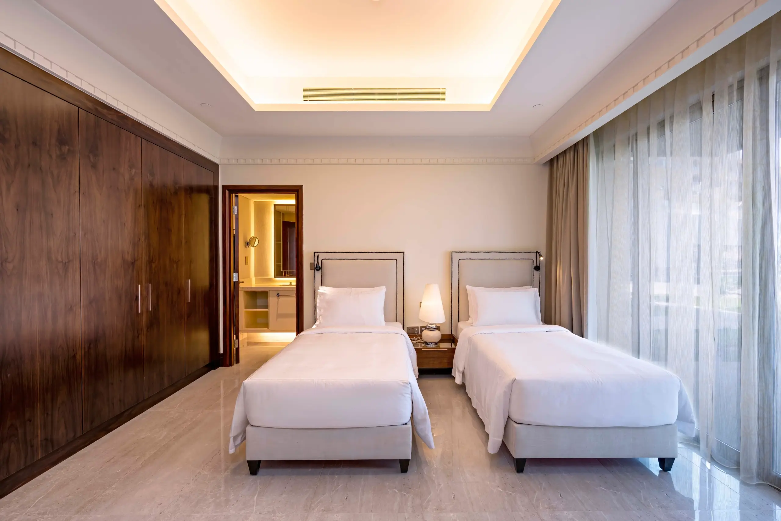 Twin bedroom with wardrobes and bathroom