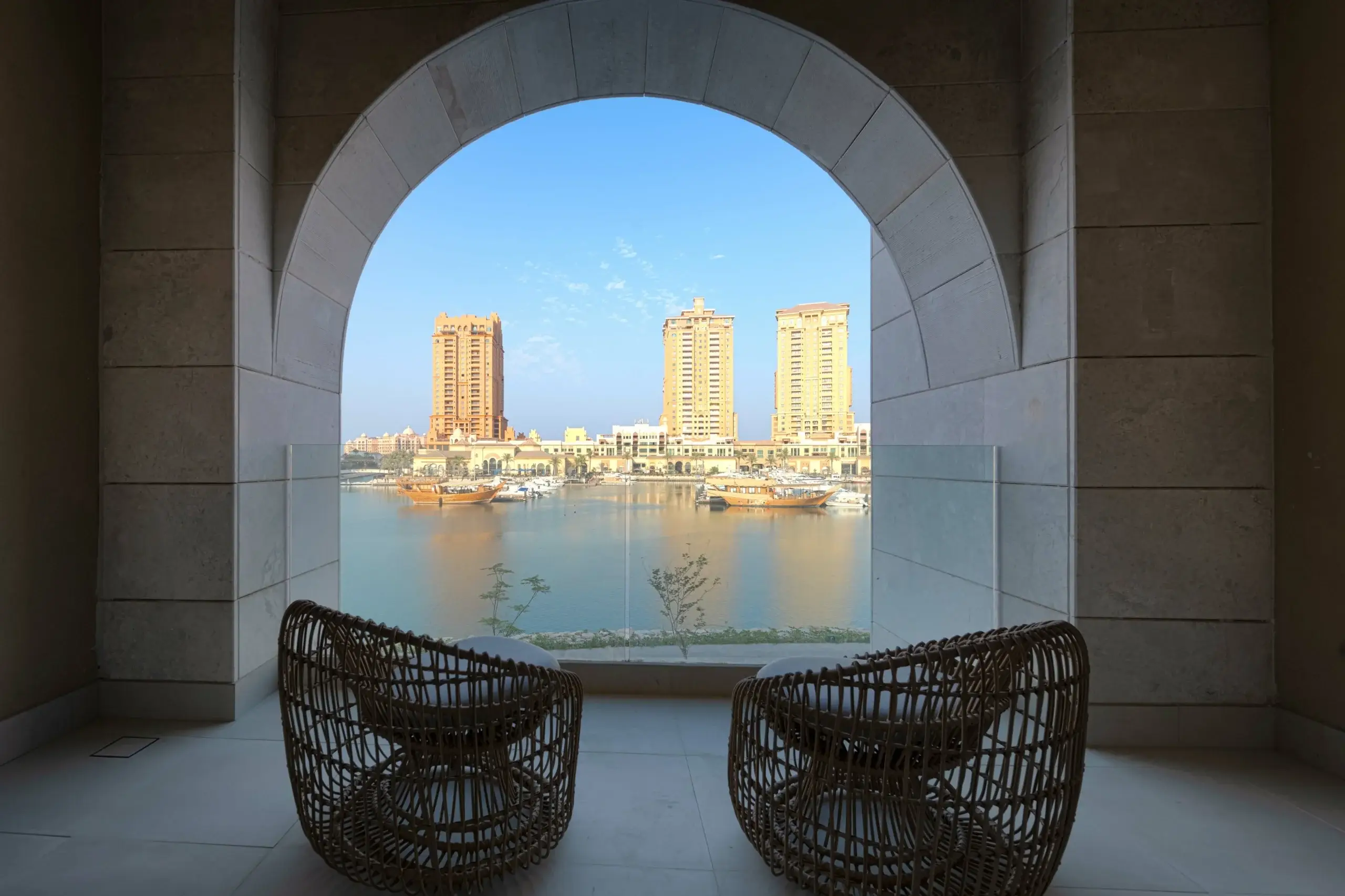 Arched balcony view of bay, buildings, boats