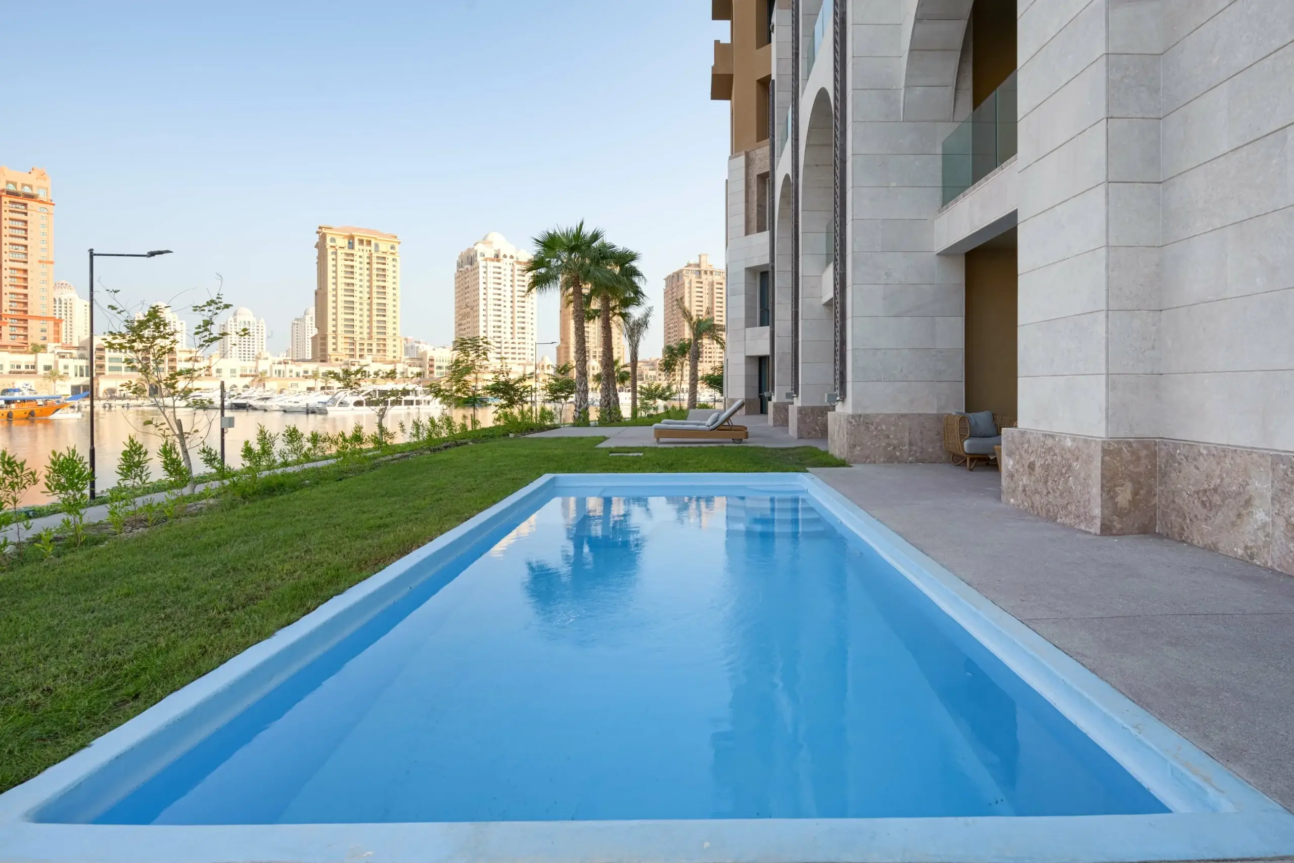 A rectangular pool outside with city views.