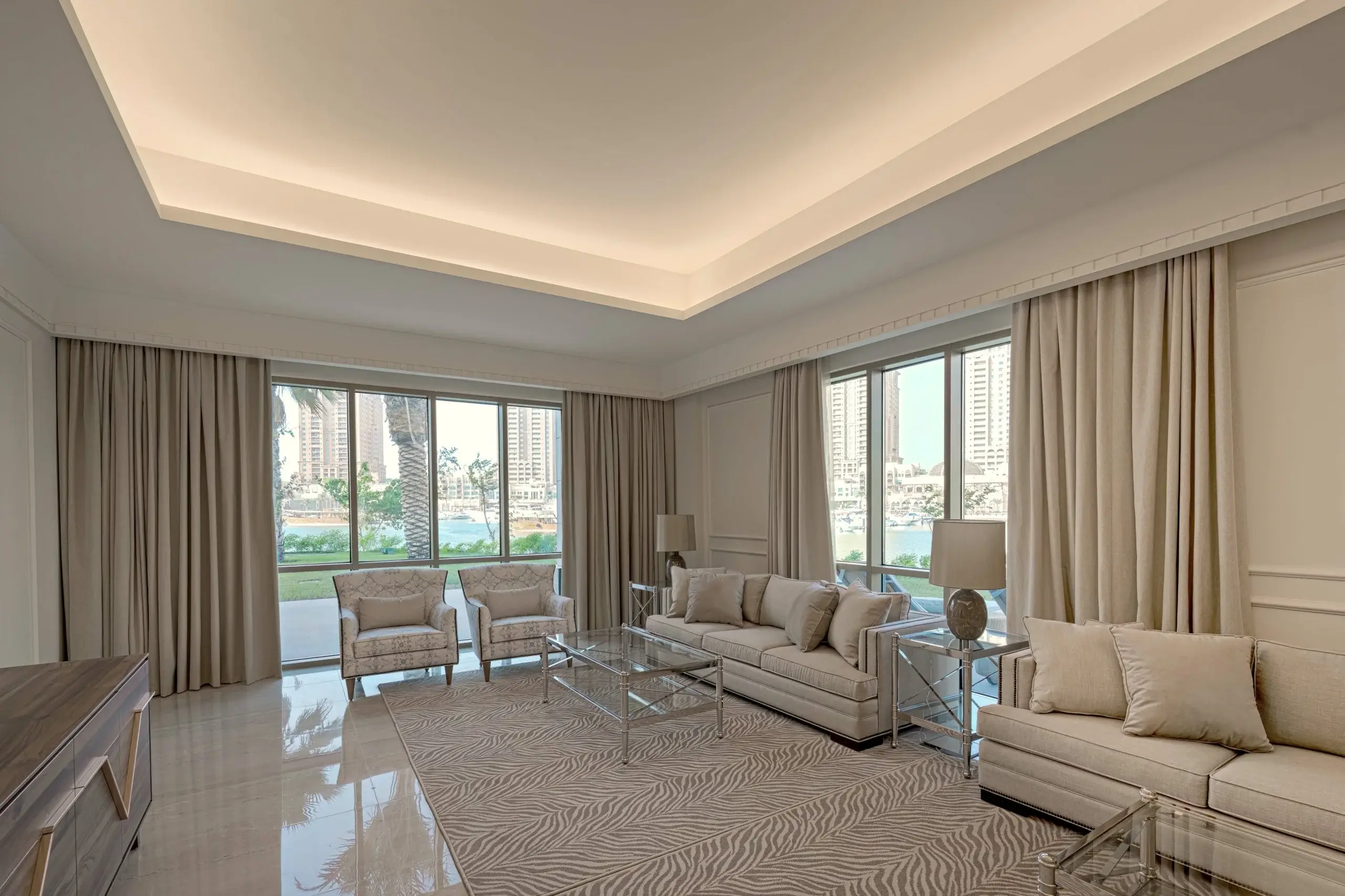 A living room with light-colored sofas and a view