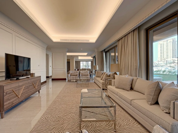 A long, luxurious living room with a TV and sofas