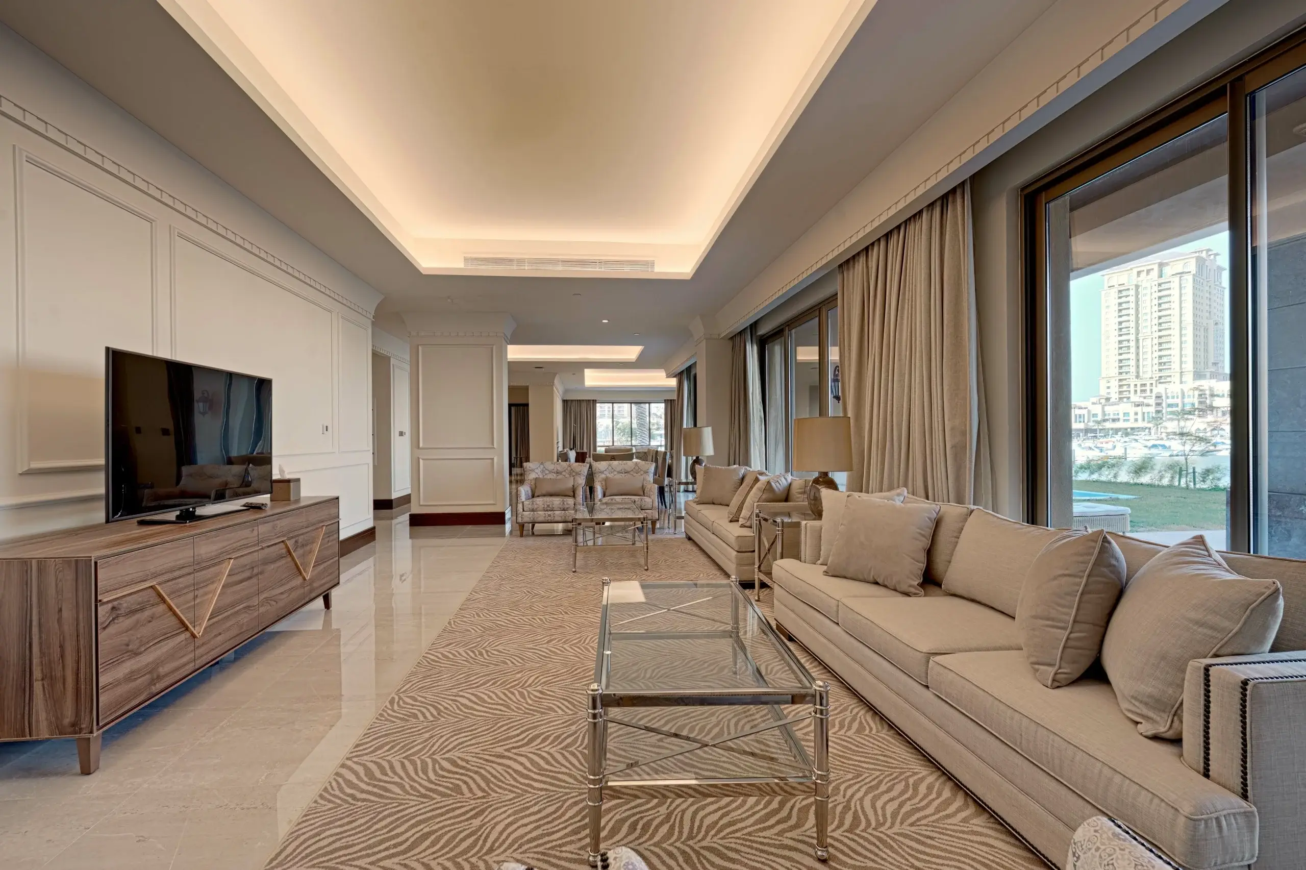 TH-710_ADD-004-scaled-1 A long, luxurious living room with a TV and sofas