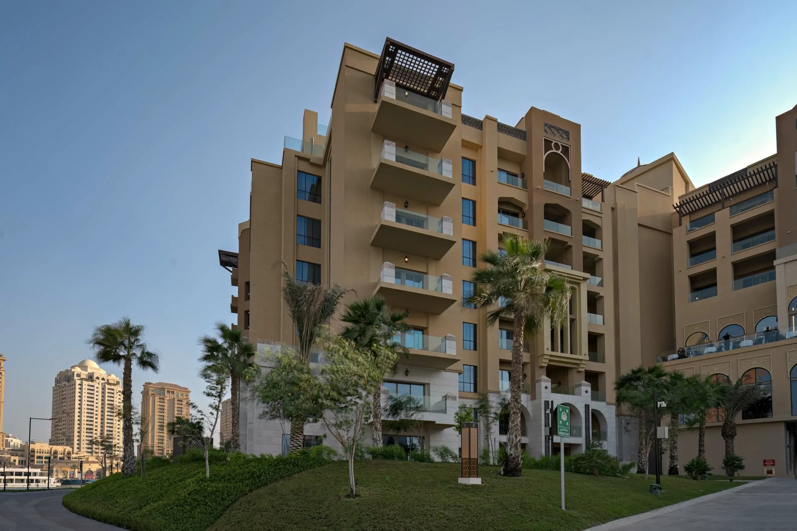 A large, modern building with balconies and palm trees
