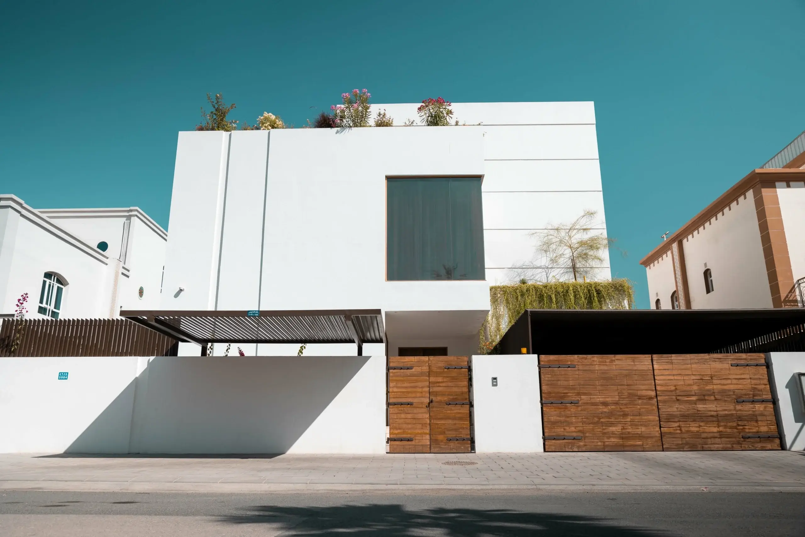 A modern white house with a wooden gate