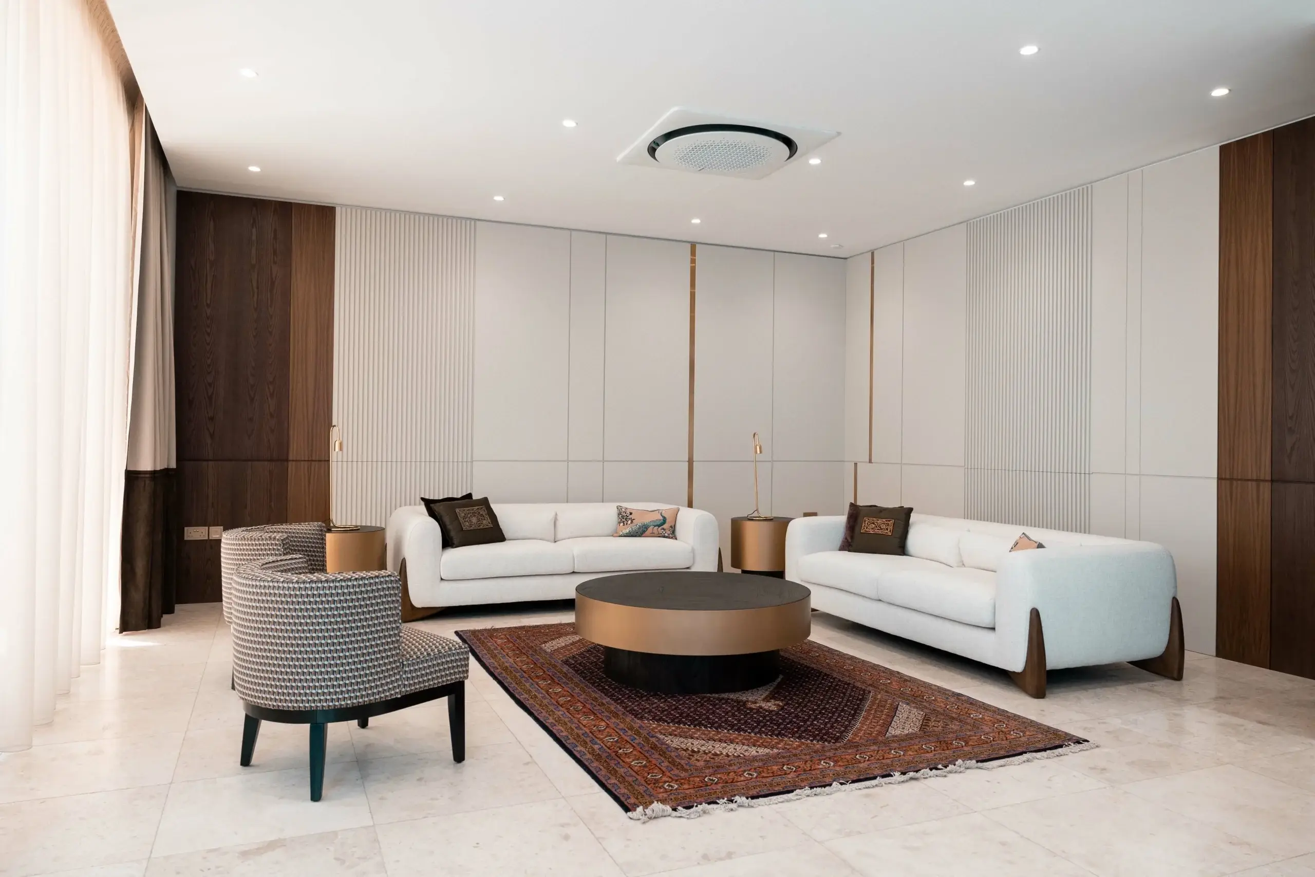 Stylish living room with white sofas, rug, and wood.