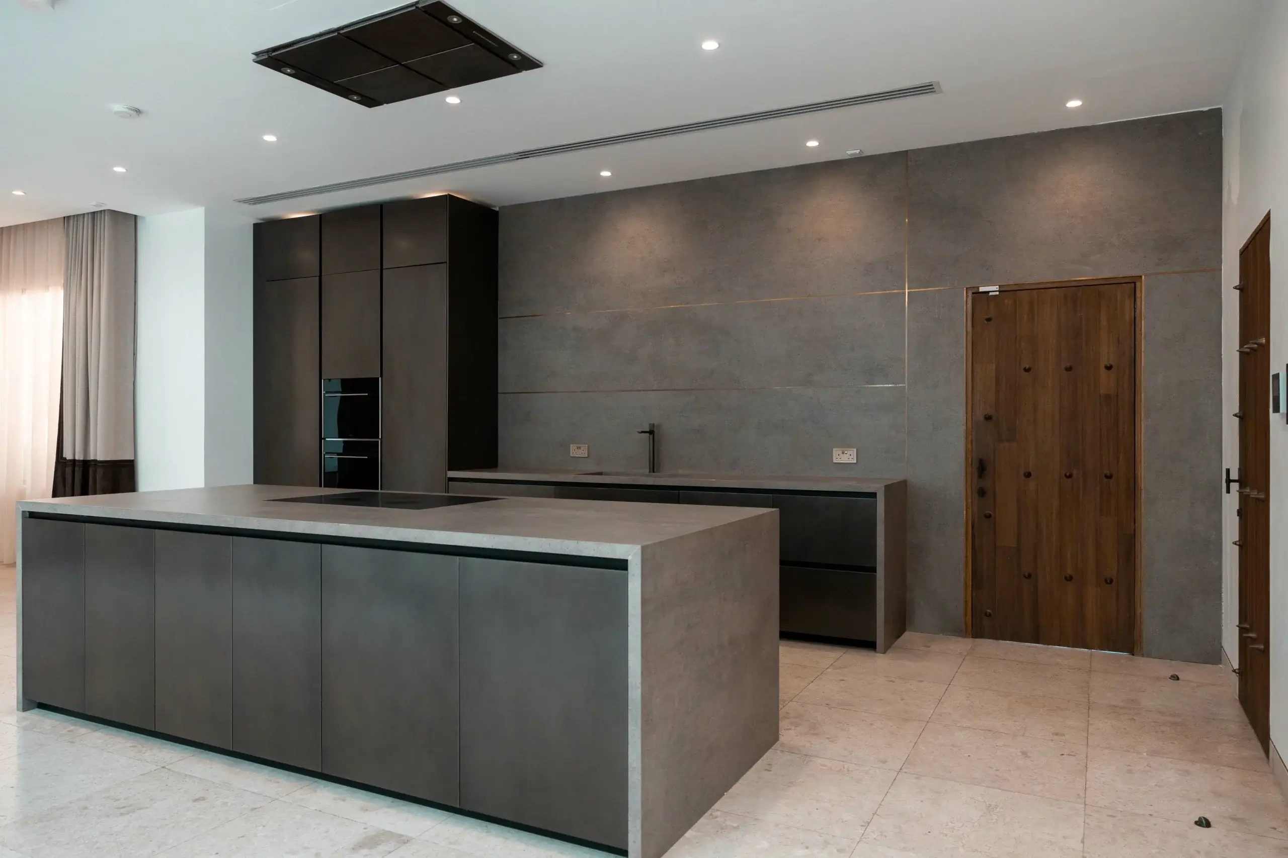 Modern kitchen with large island and dark cabinets.
