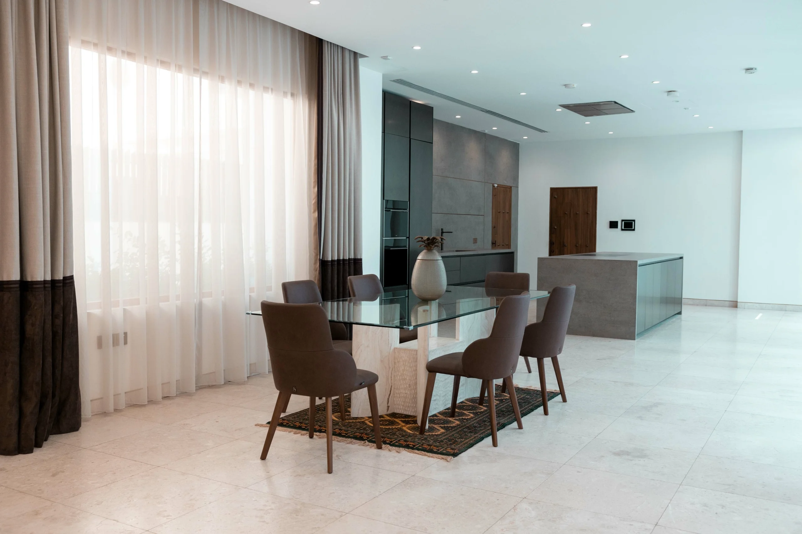 3R8A6755-scaled-1 A modern dining area with a glass table.