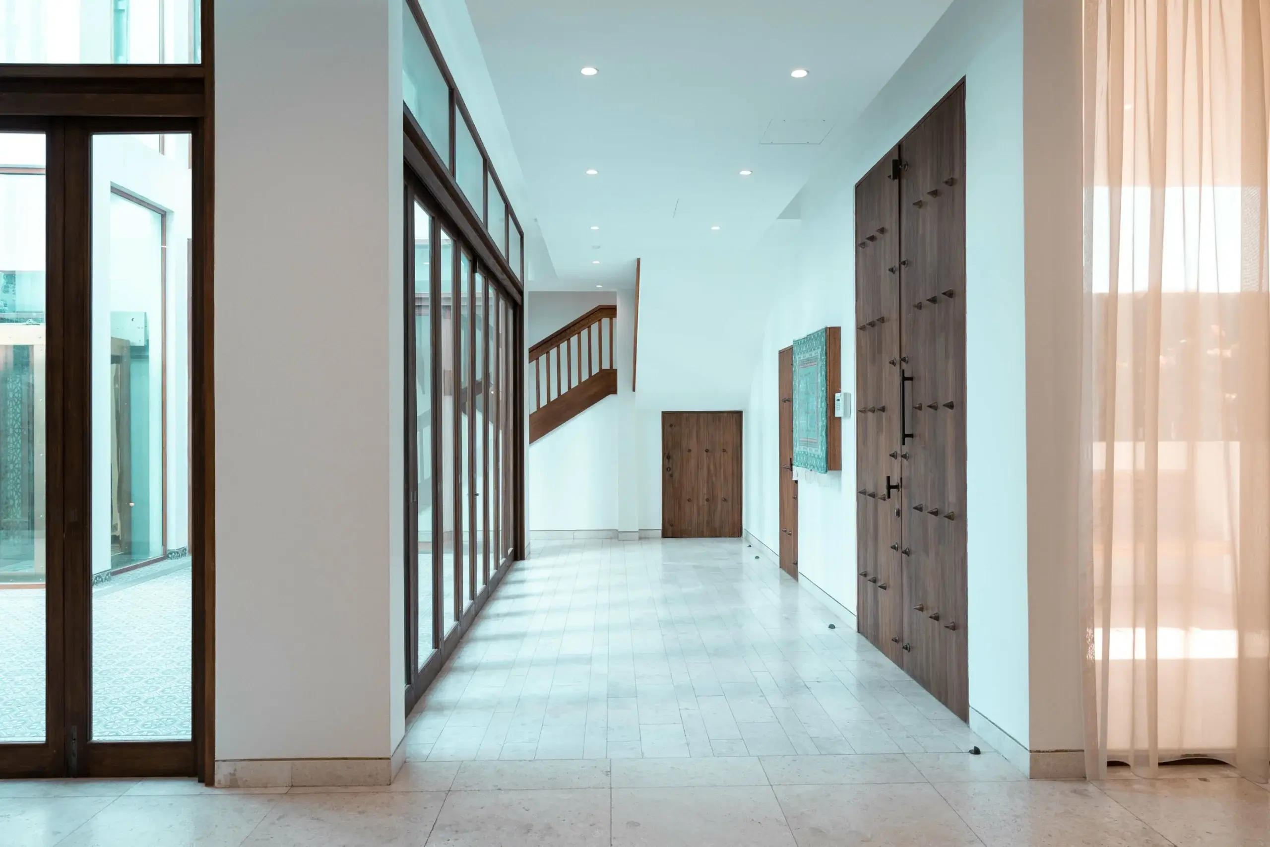 A modern hallway with wooden doors and a staircase