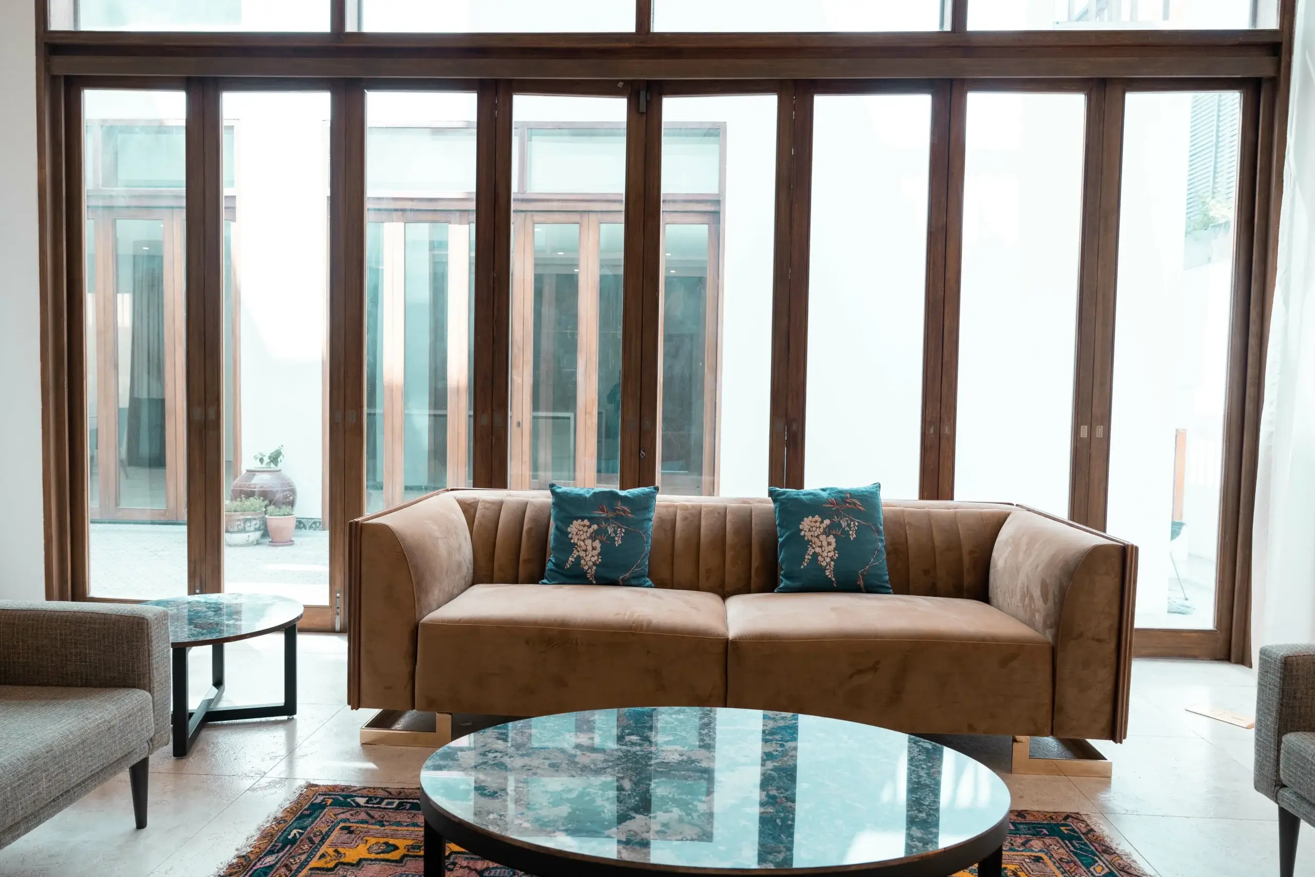 A living area with a brown sofa and large windows