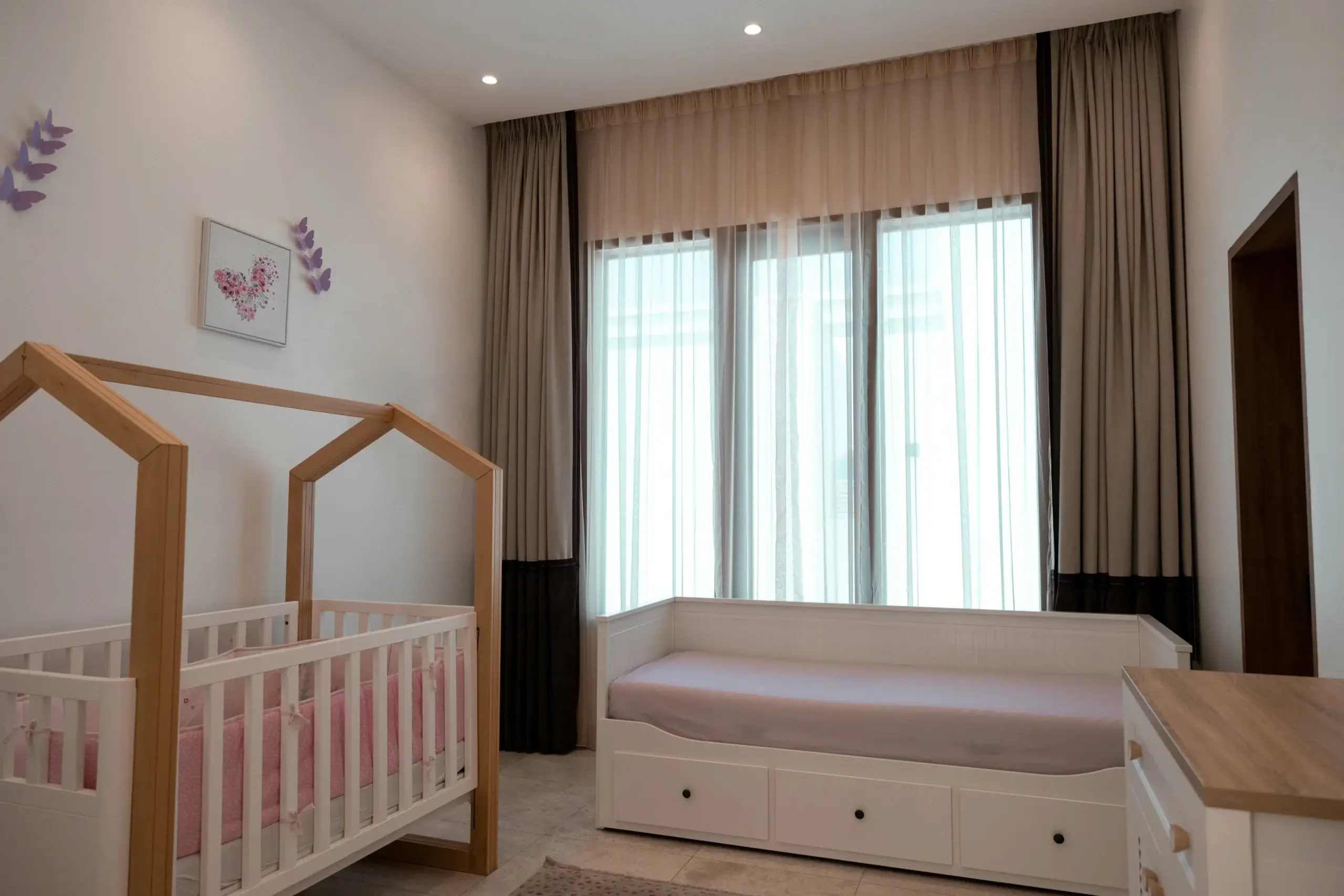 A bright nursery with a crib and a daybed