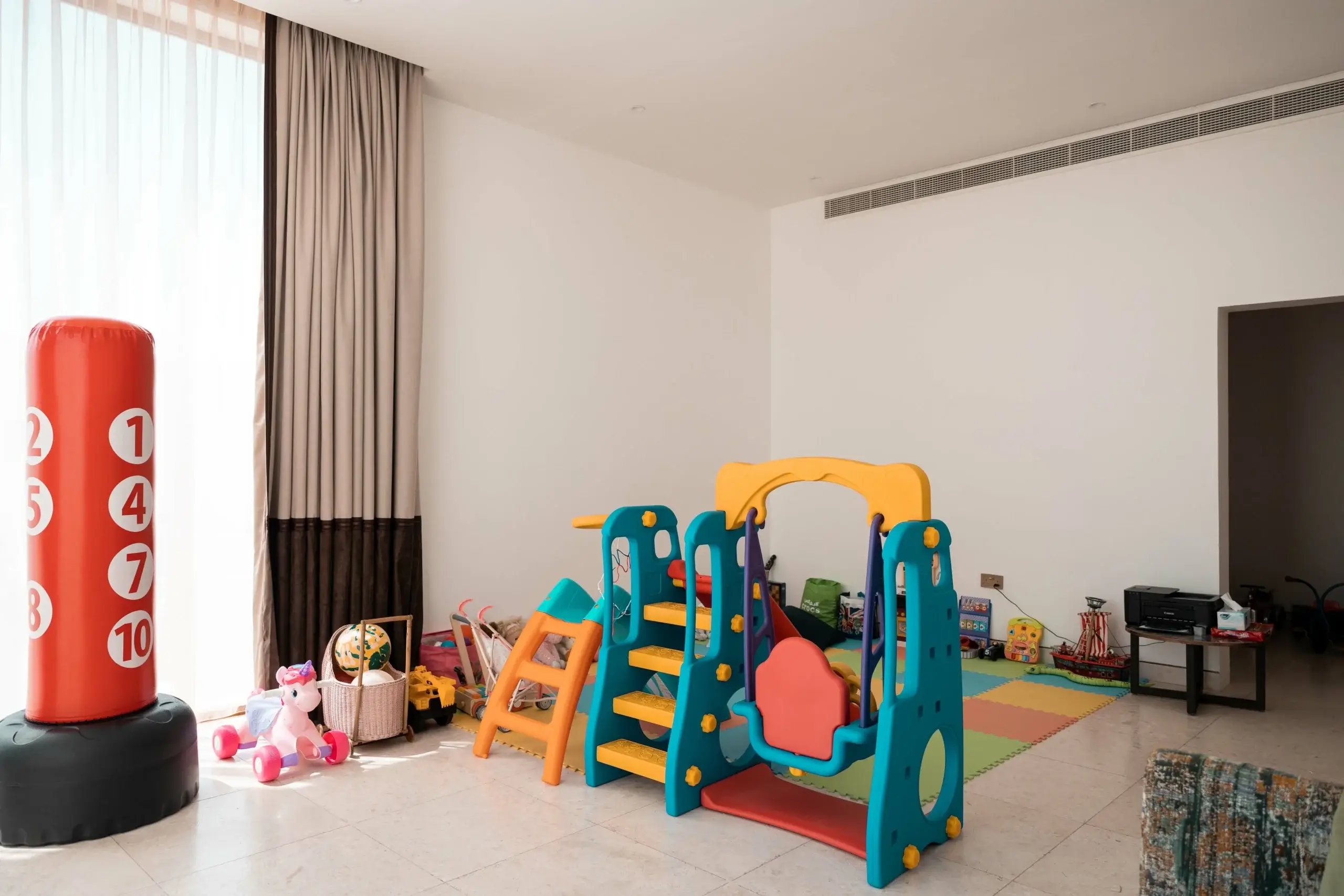 A colorful playroom with a slide and a punching bag