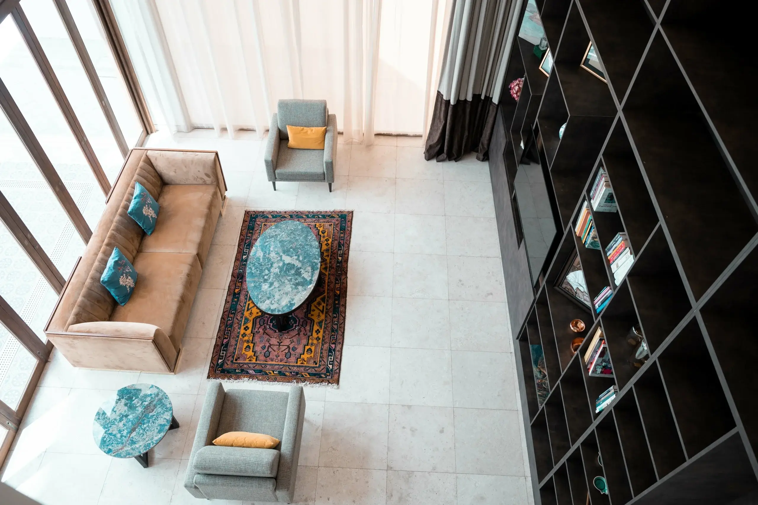 High-angle living room with sofa, chairs, bookshelf.