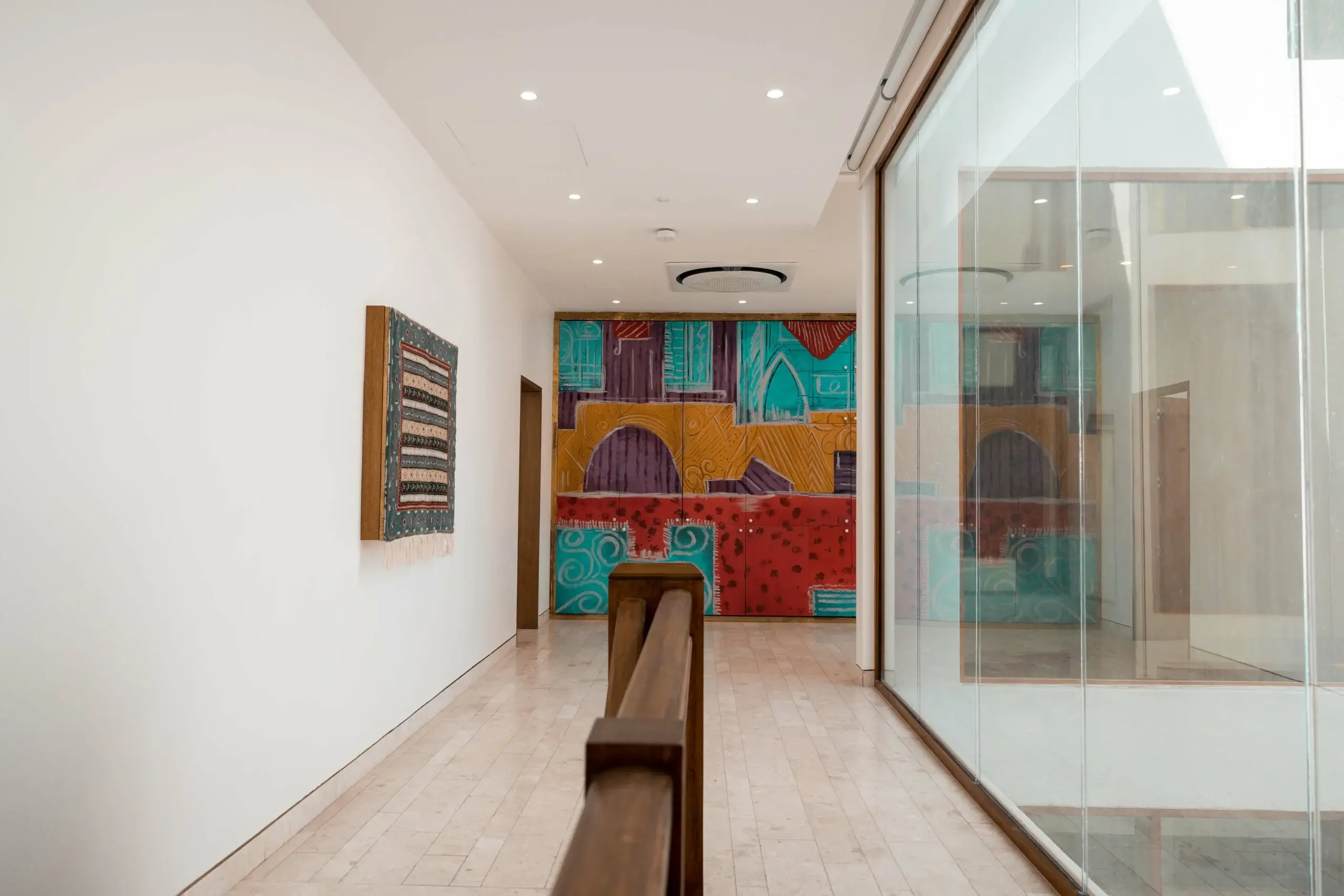 Bright modern hallway with abstract art and glass.