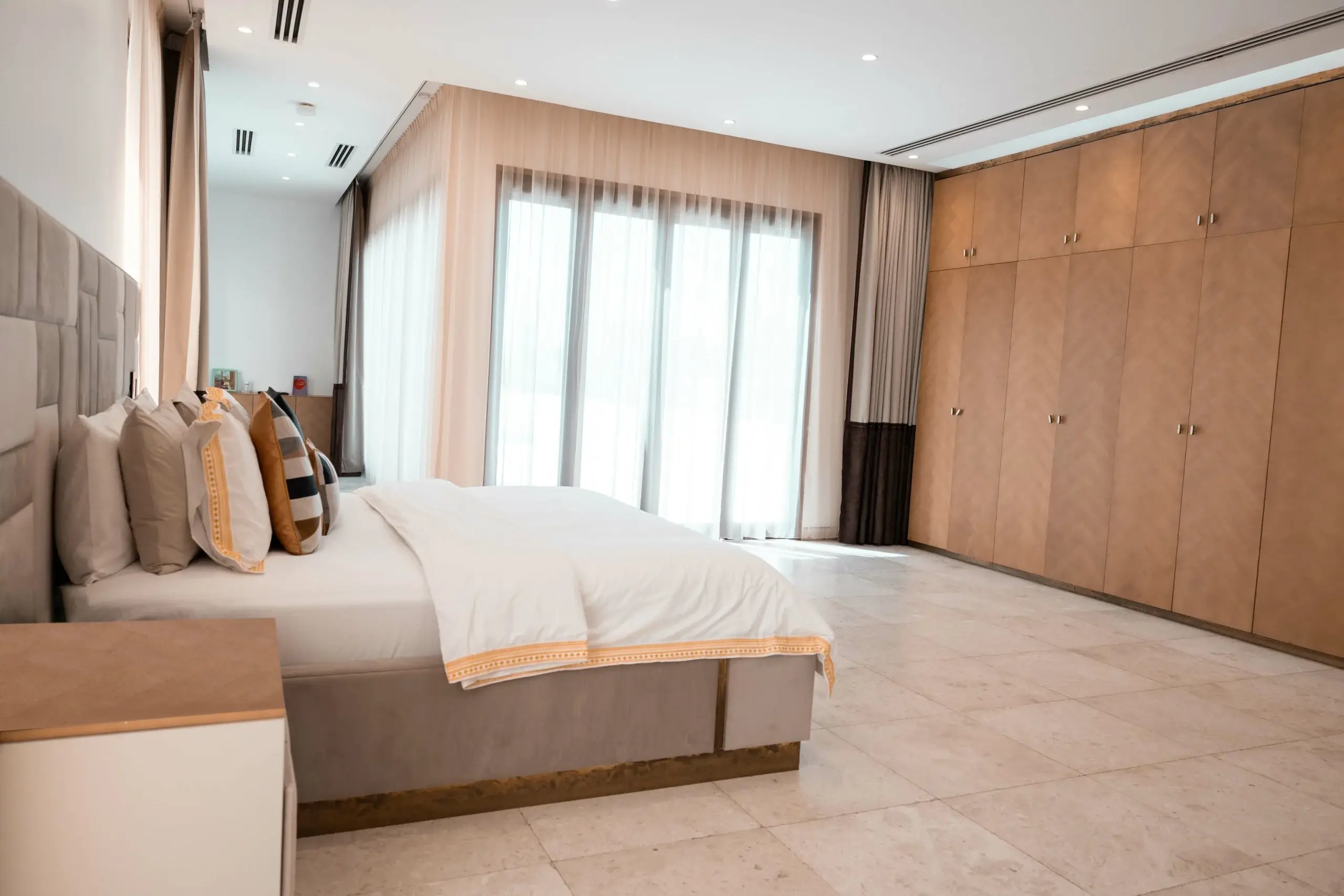 Master bedroom with bed, large window, and wardrobe.