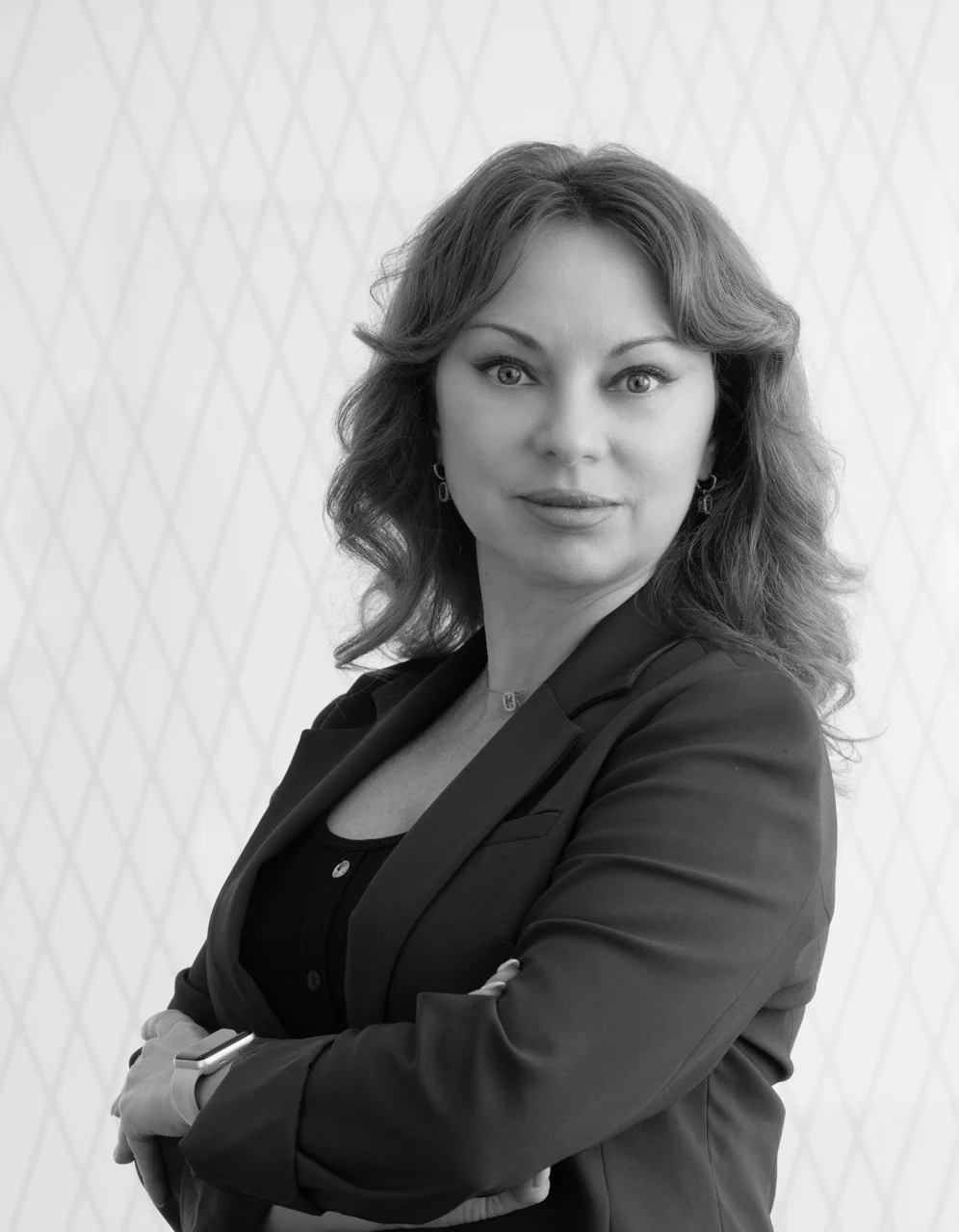 A black and white headshot of a woman with long hair