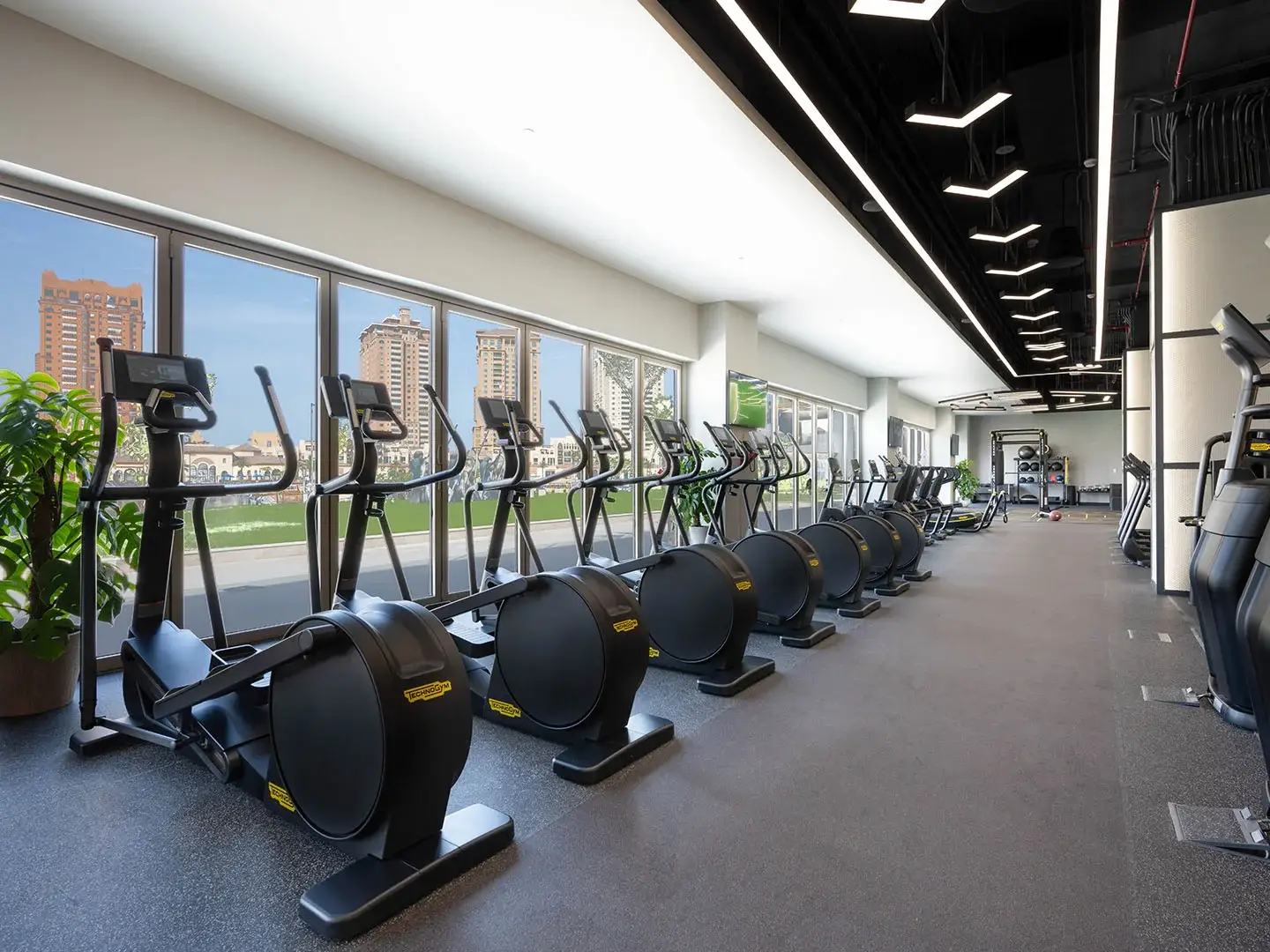 Large gym with ellipticals and city views.