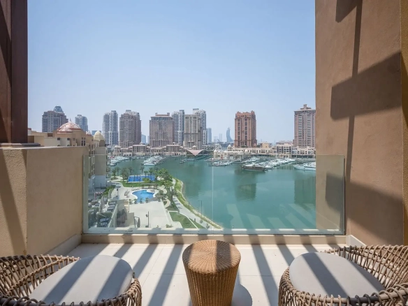 Balcony with chairs overlooking marina and city.