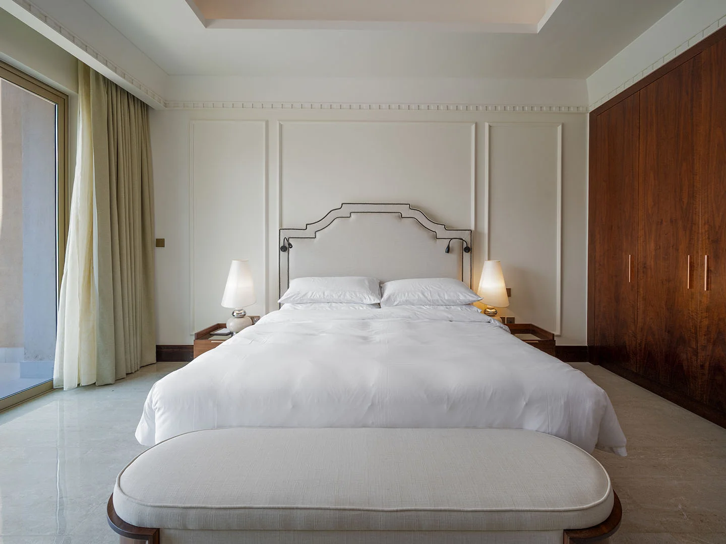 A spacious bedroom with a large white bed.