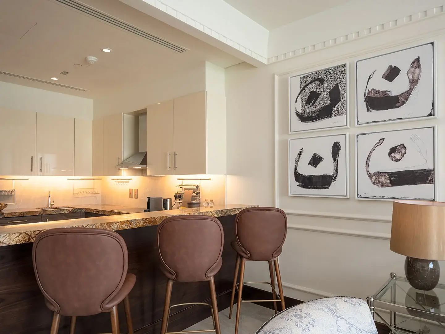 Kitchen counter with stools and wall art.