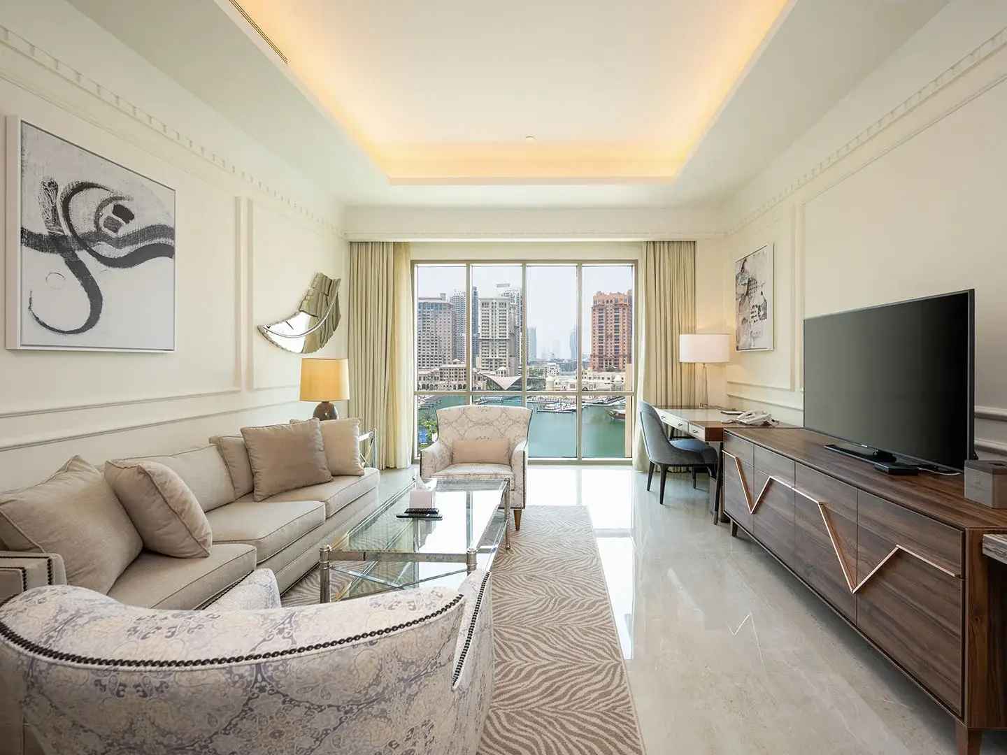 Living room with sofa, chairs, and city view.