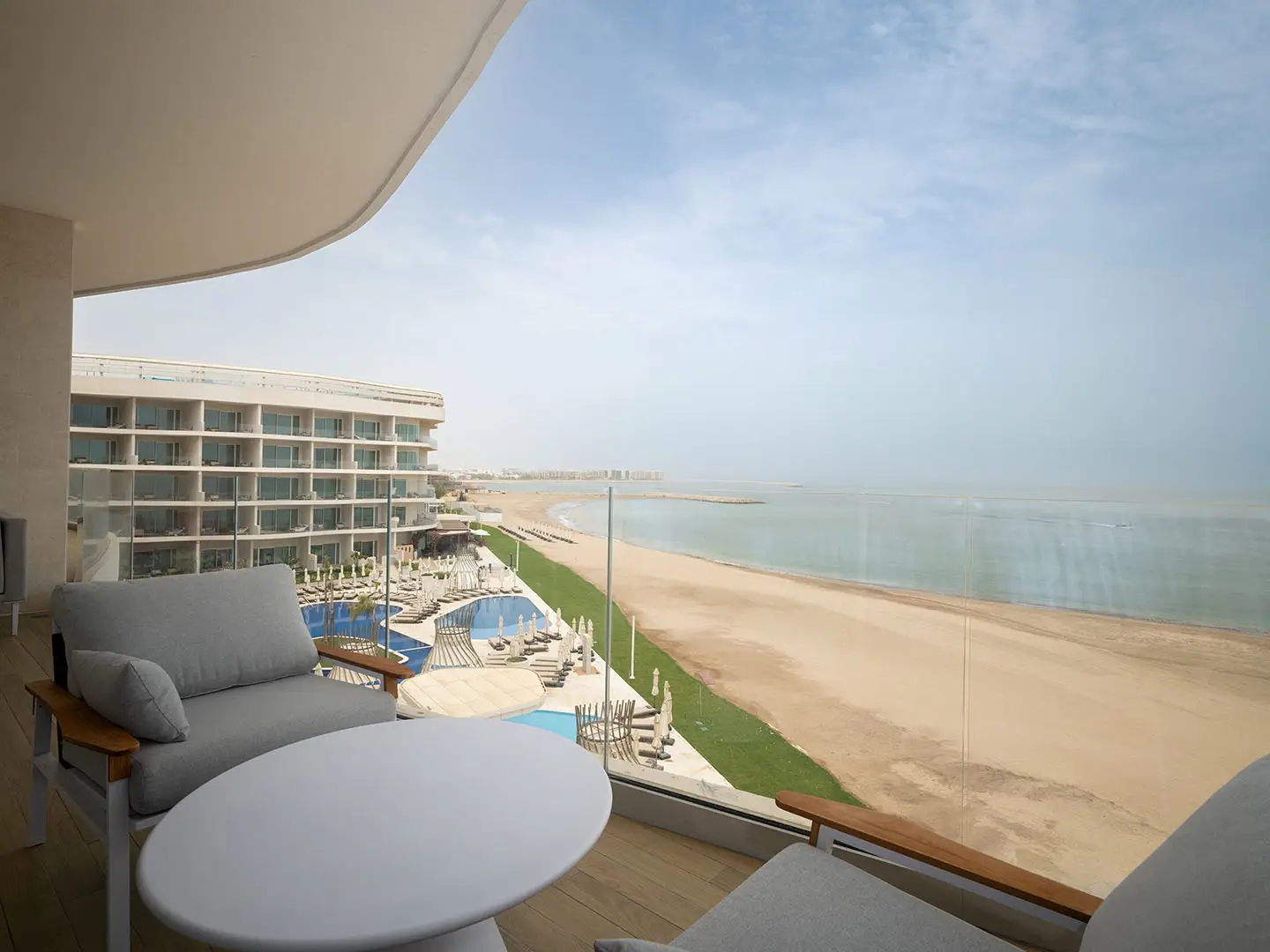 Balcony view of beach, sea, and hotel.