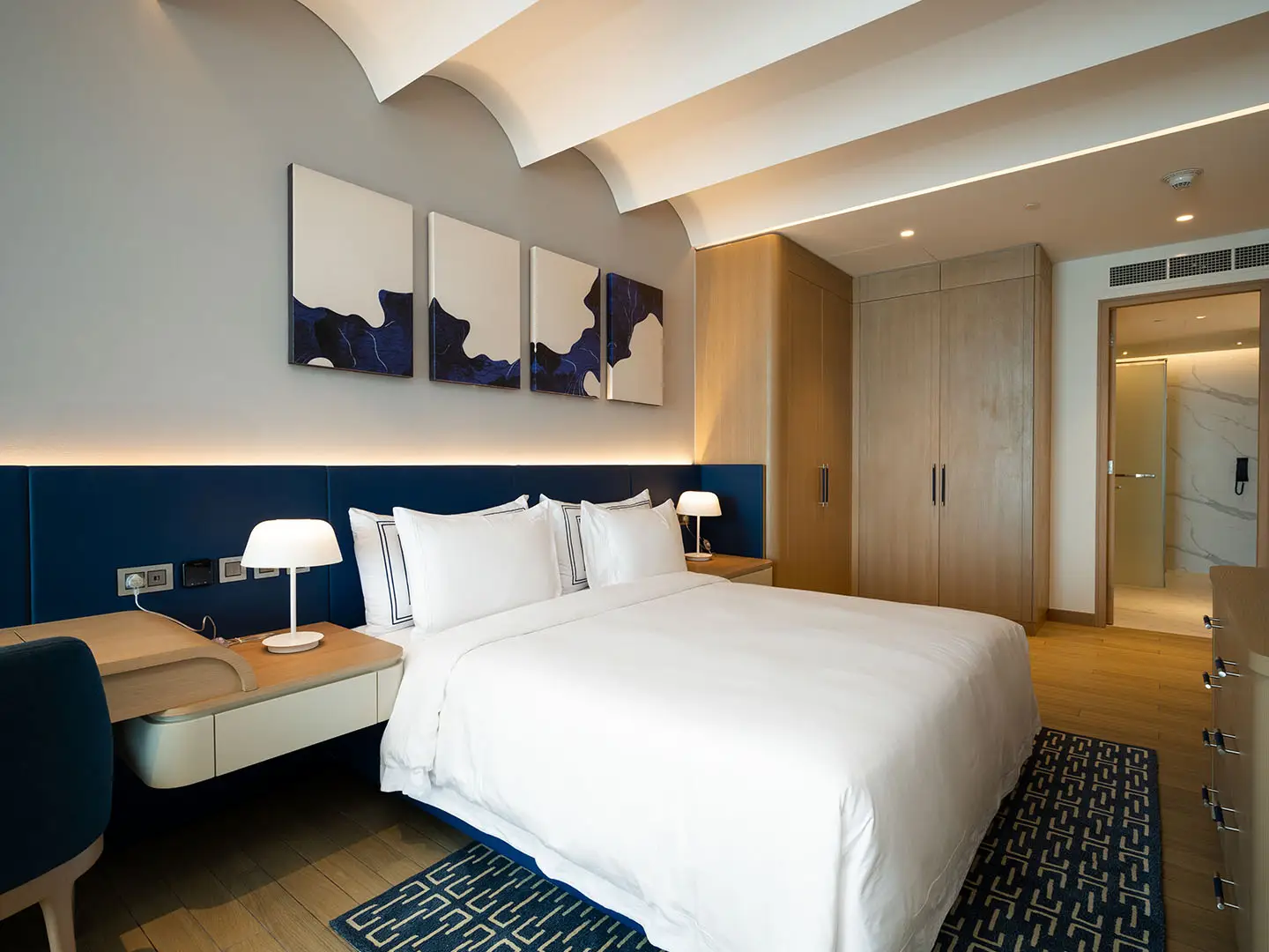 Bedroom with large bed and blue accents.