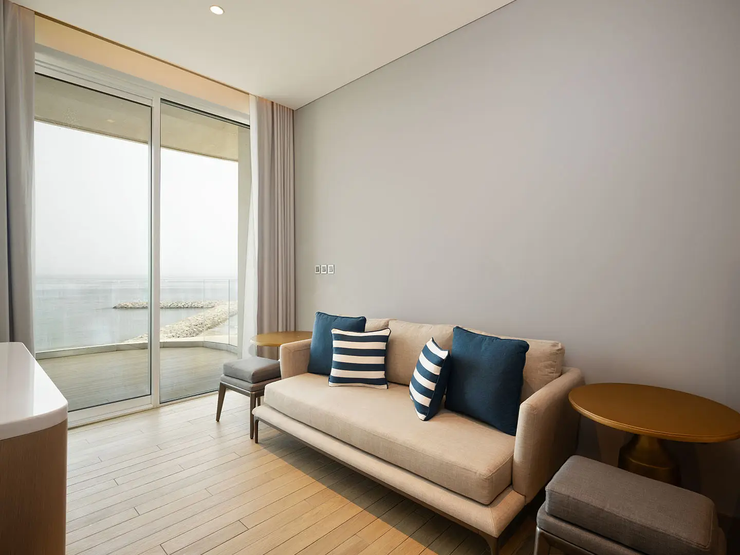 Living room with couch, pillows, and sea view.