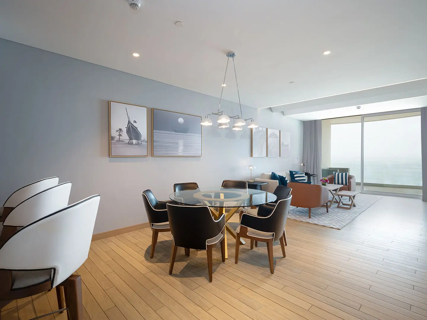 Dining area with round table, chairs, and art.