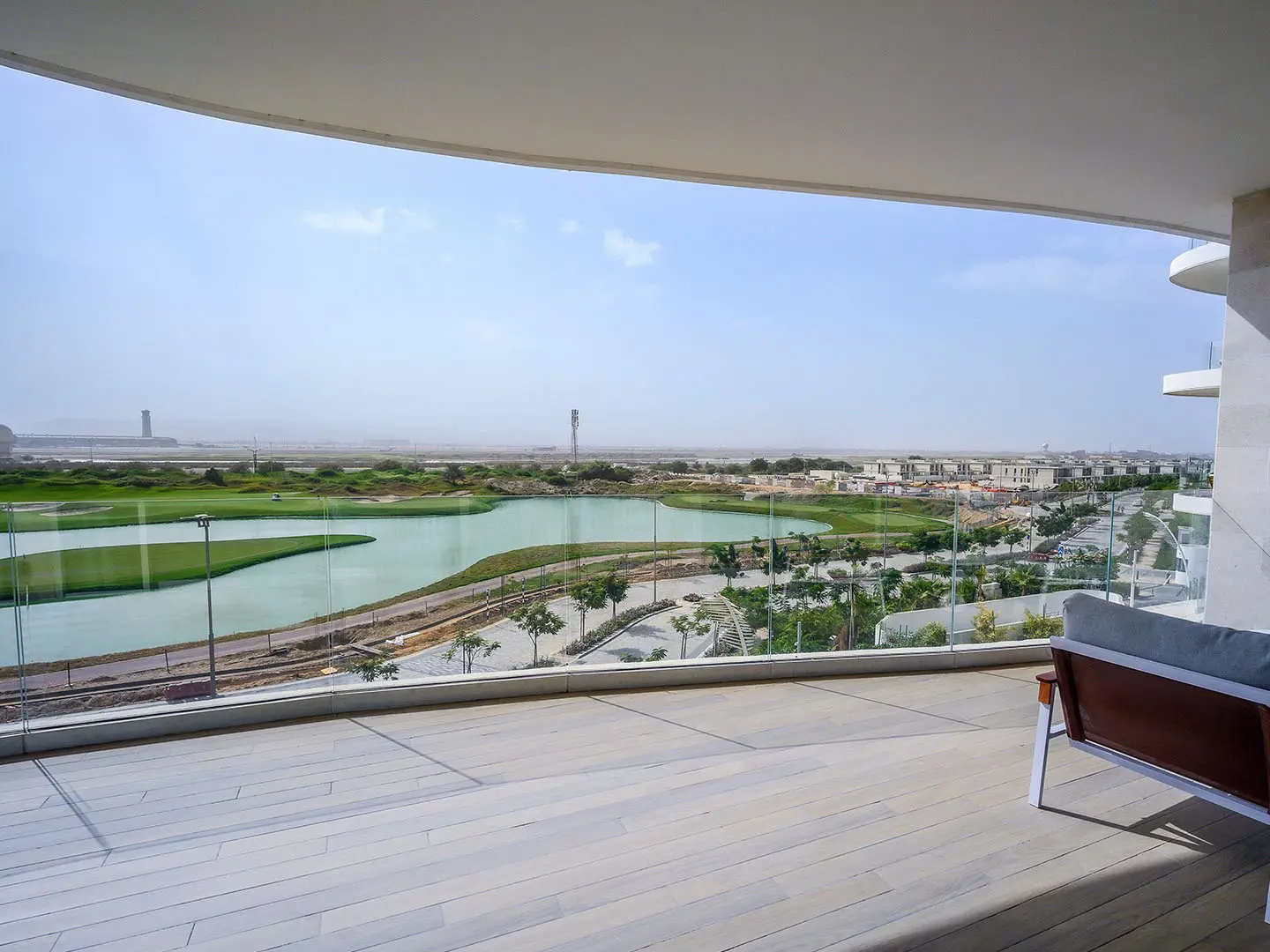 Balcony view of golf course, lake, and city.