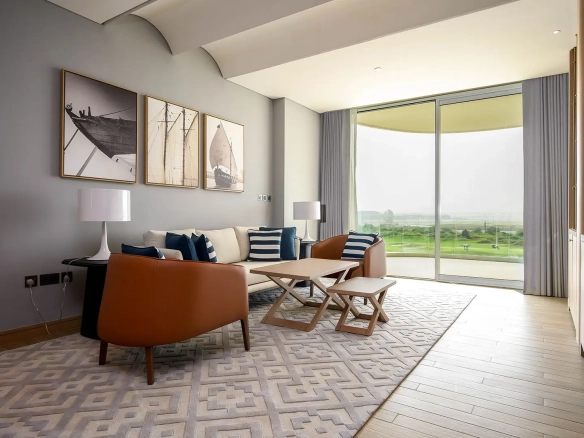 A bright living room with a sofa, chairs, and large window