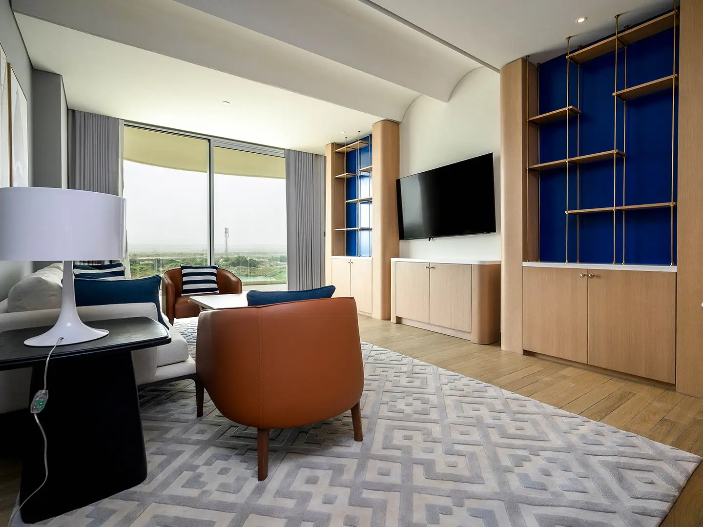 Contemporary living room with TV and large window.