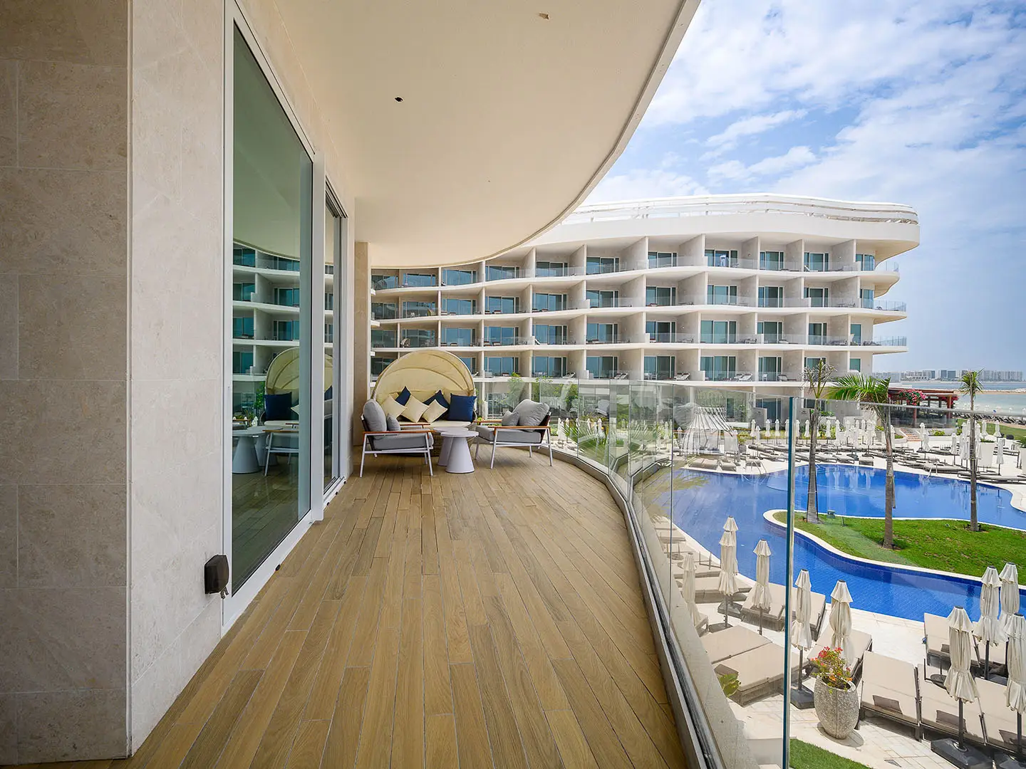 A spacious balcony overlooking a pool and hotel
