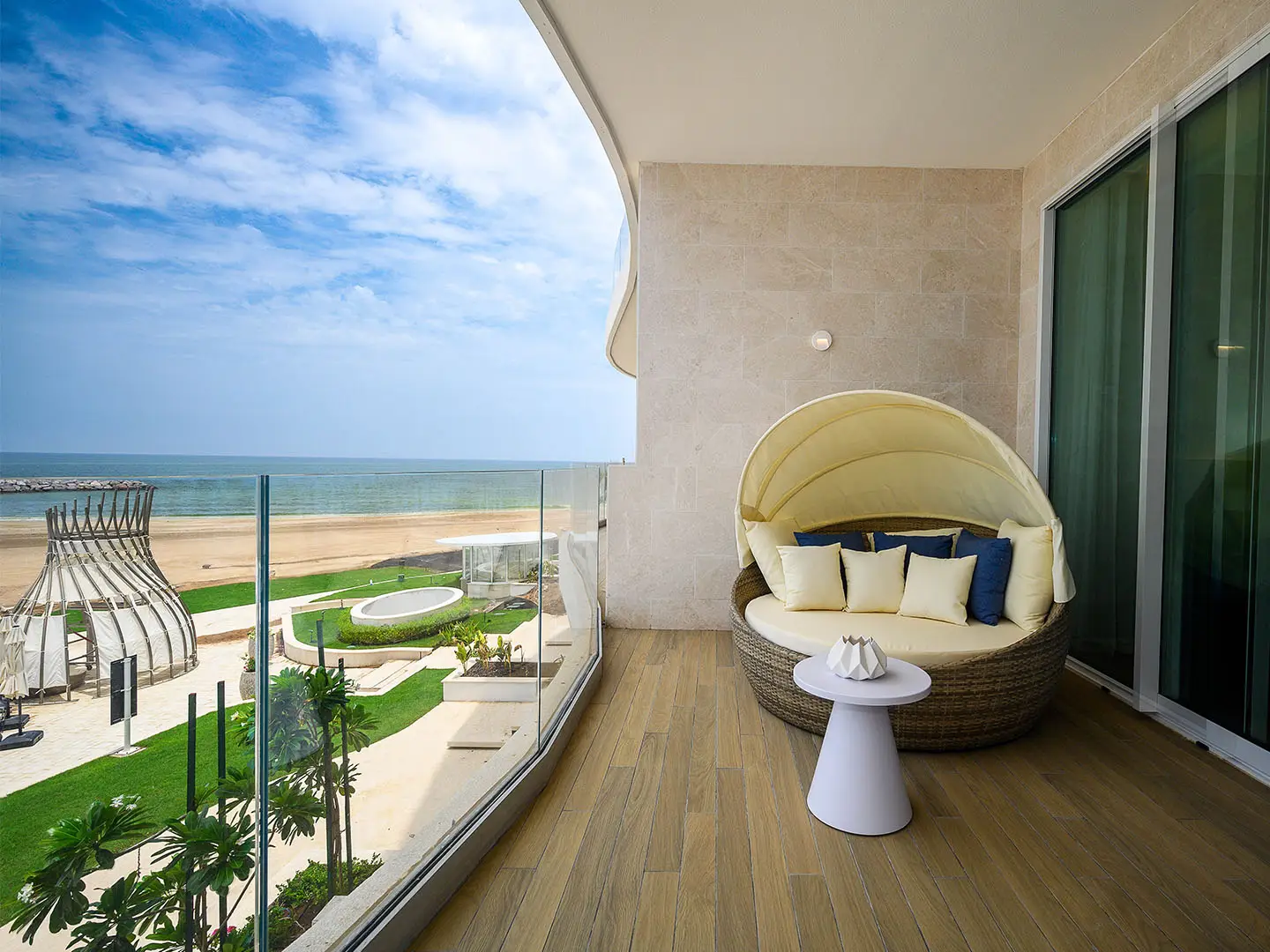 A balcony with a curved sofa facing the sea