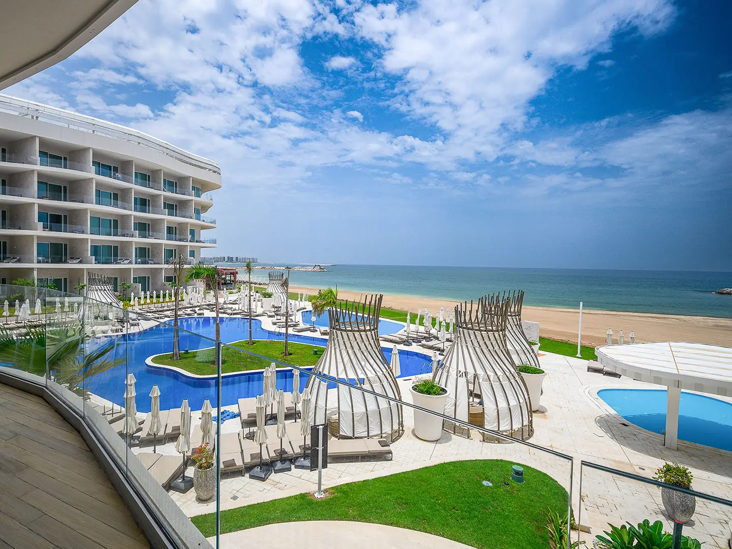 A resort with a large pool, beach, and ocean view