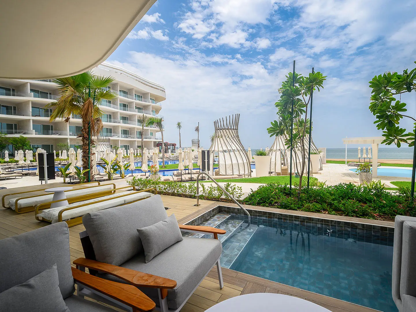 An outdoor patio with lounge chairs and a small pool