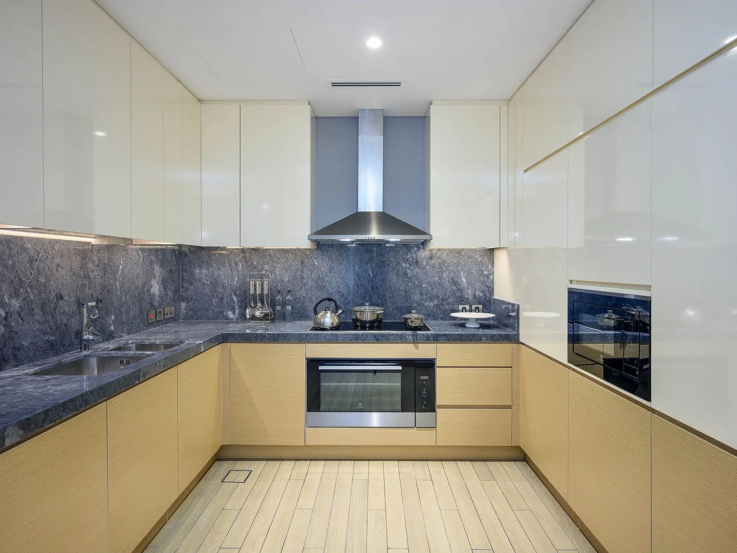 A contemporary kitchen with light wood and white cabinets