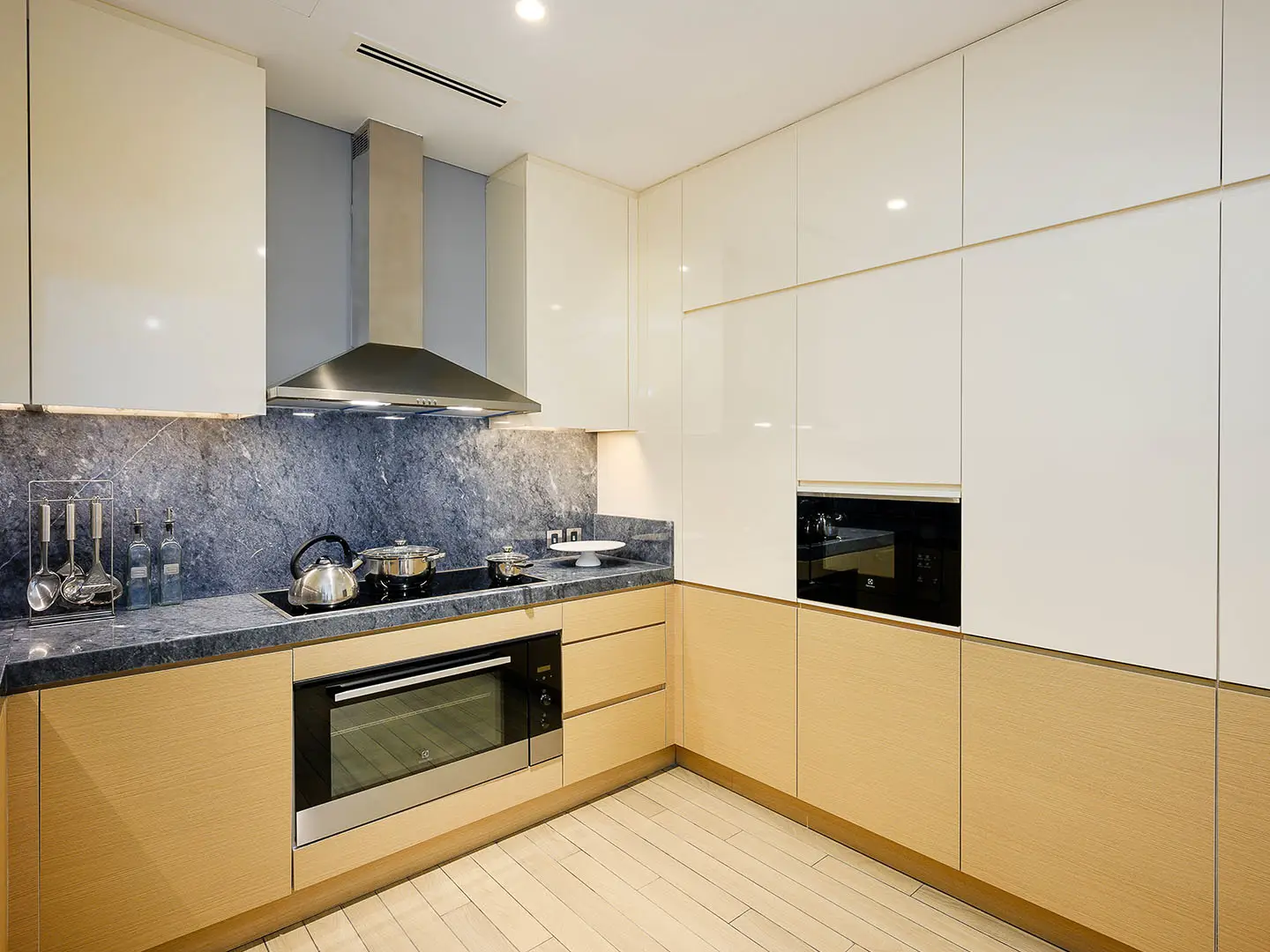 A contemporary kitchen with light wood and white cabinets