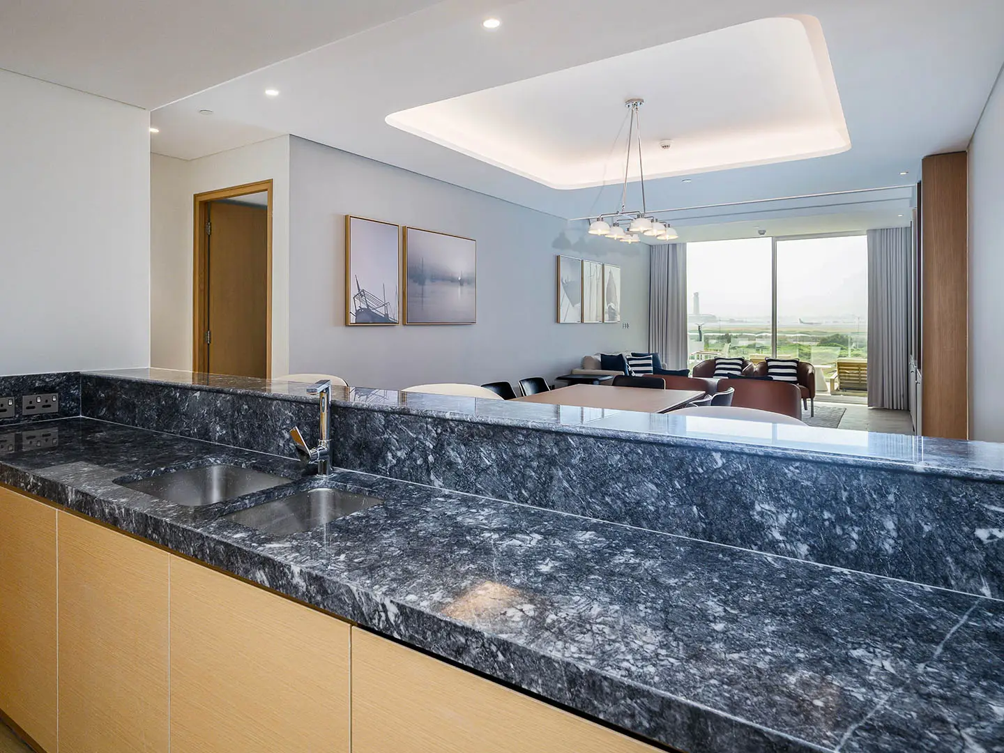 A modern kitchen counter overlooking a living room.