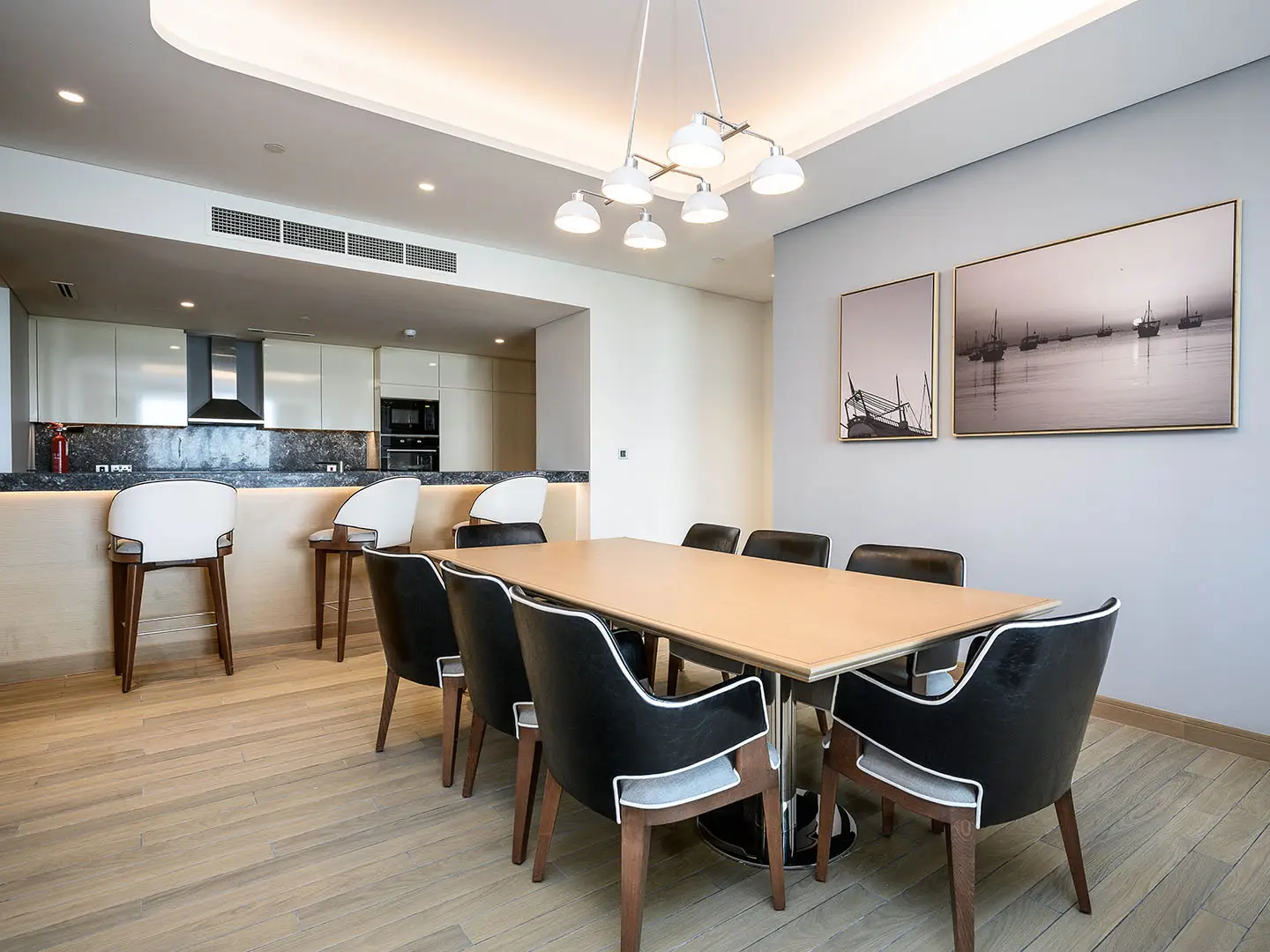 A dining room with a table and chairs, next to a kitchen