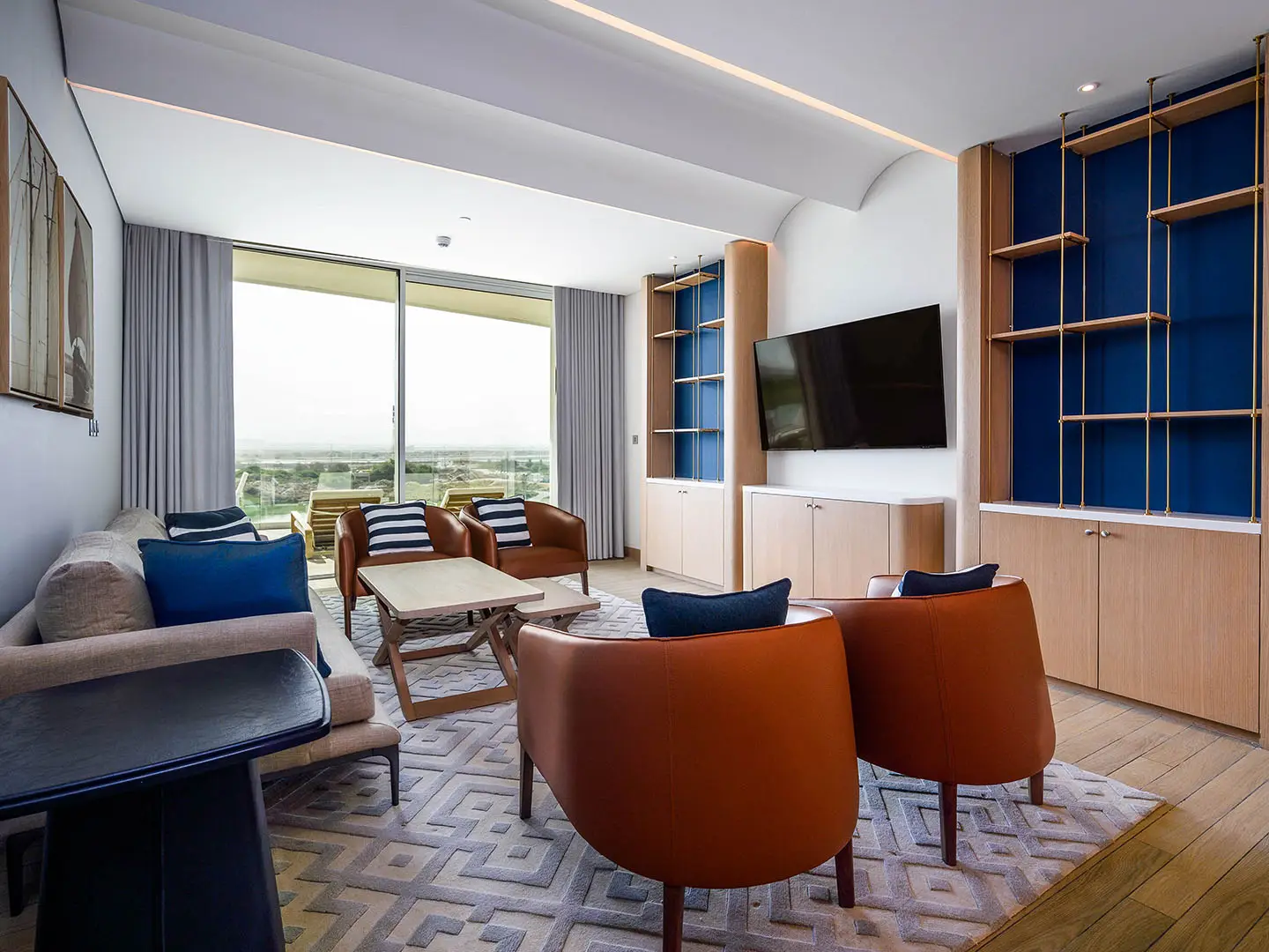 A modern living room with a TV and balcony.