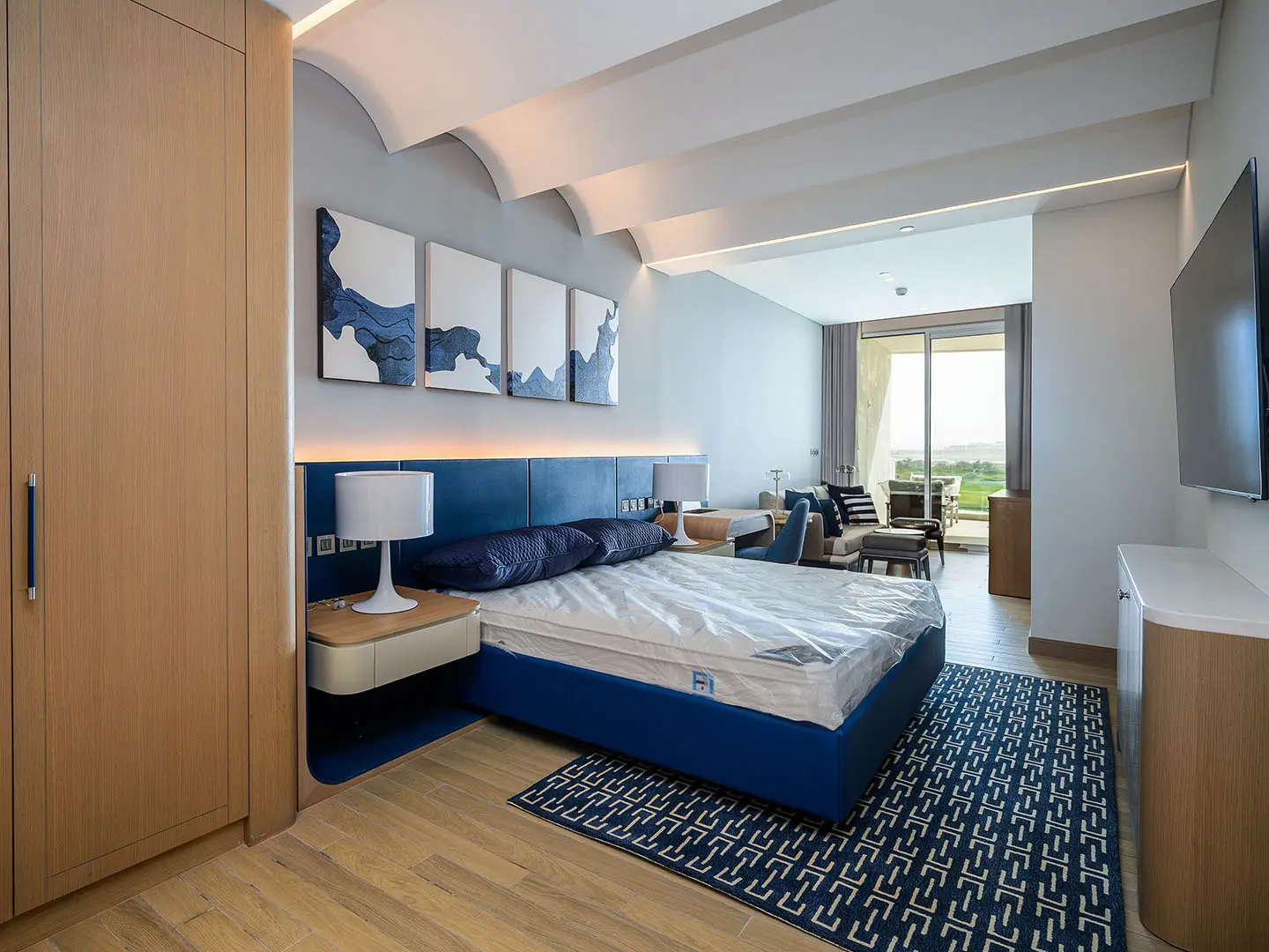 A spacious, modern apartment bedroom with a large bed