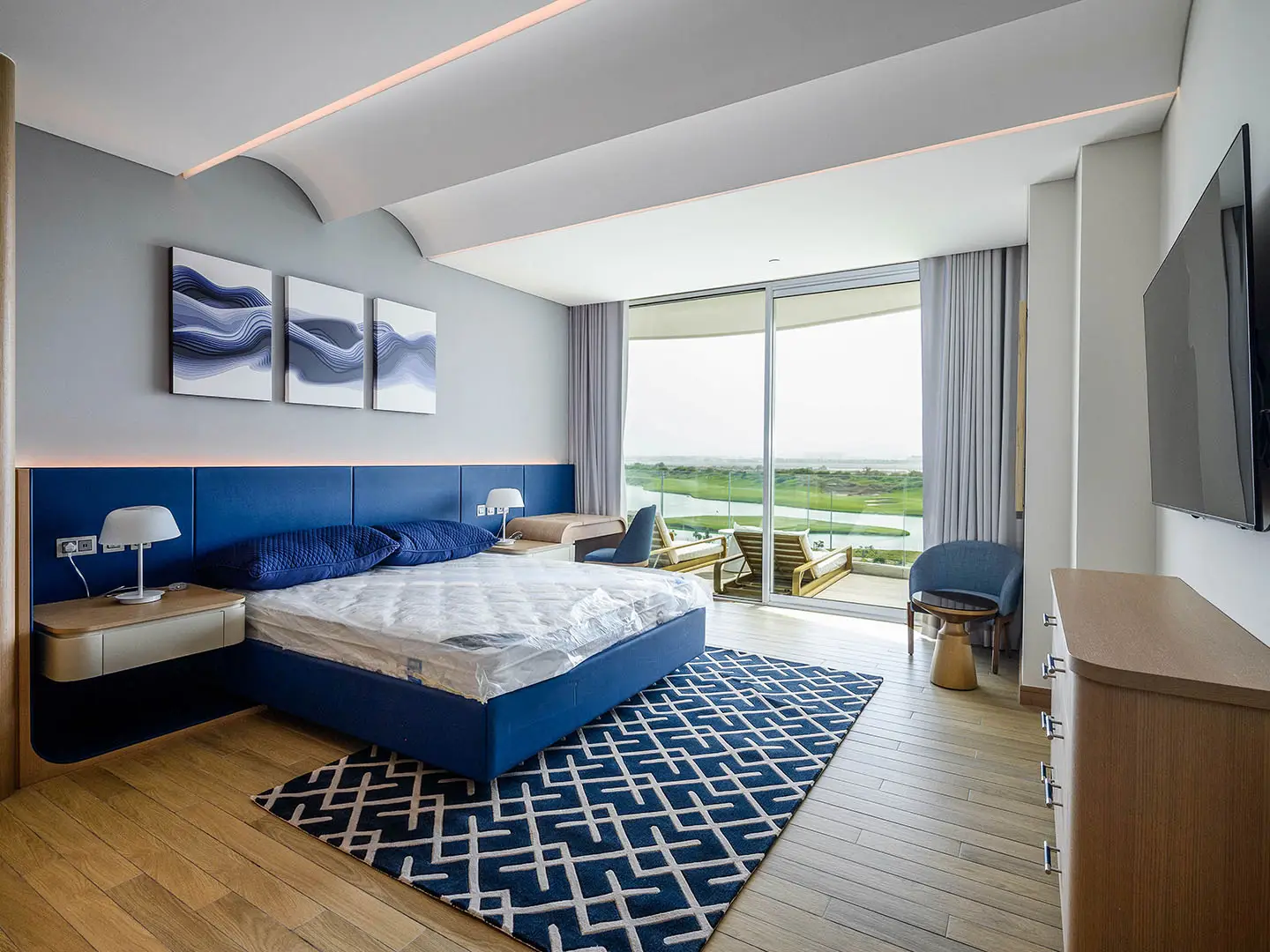 A stylish bedroom with blue accents and a large window