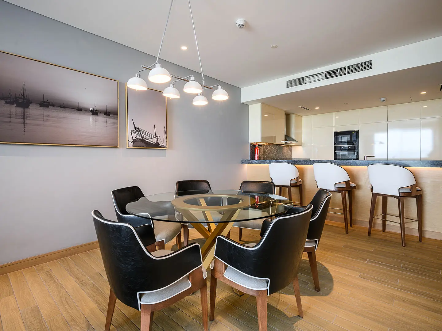 A chic dining room with a glass table and black chairs