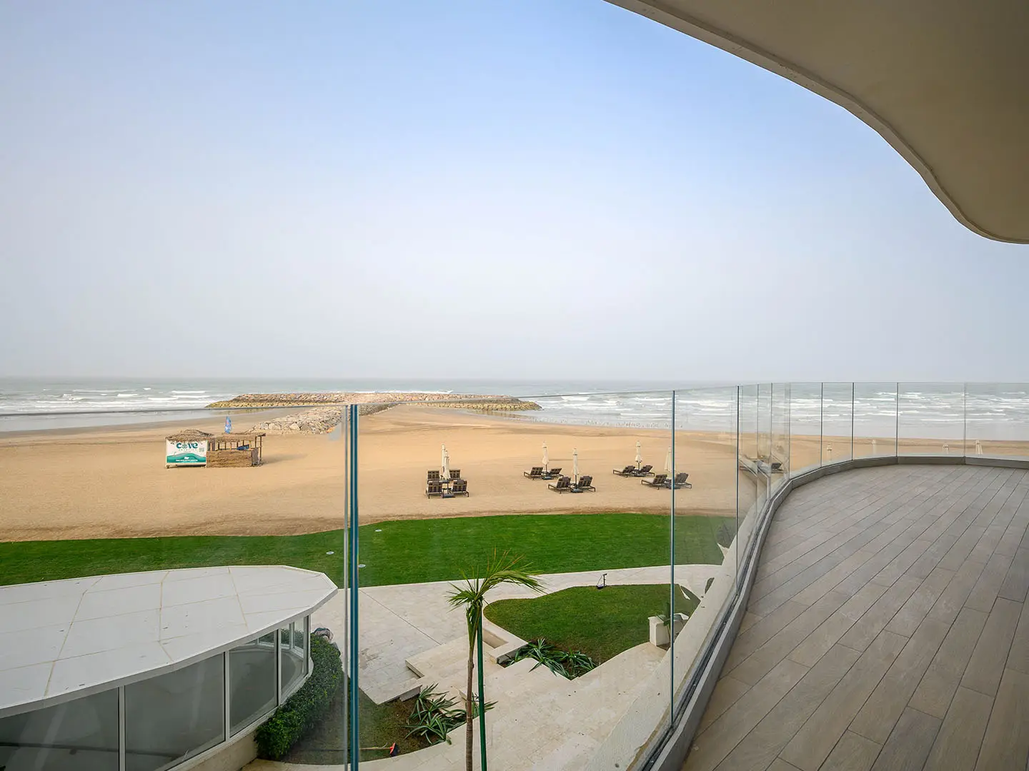 Beachfront balcony with ocean view and lounge beds