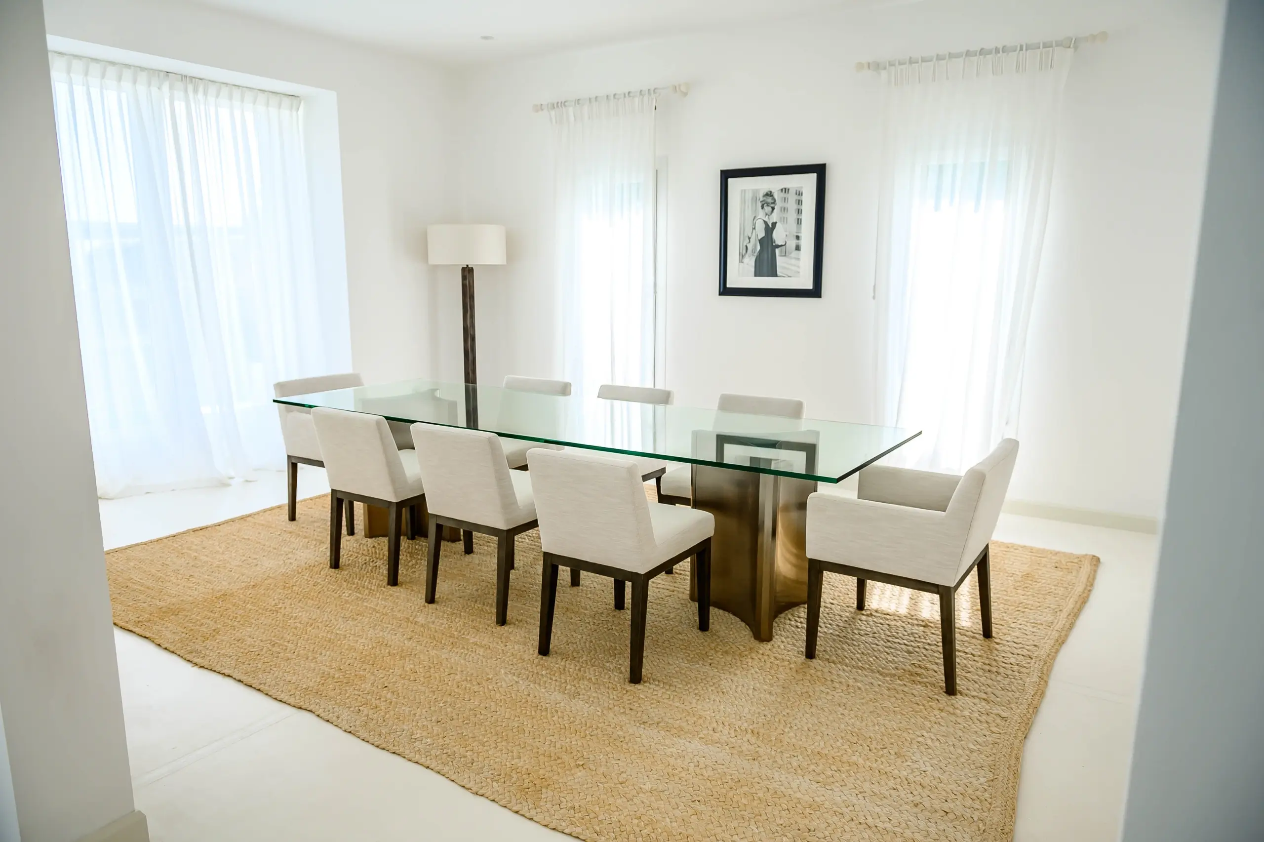 A dining room with a glass table and chairs.
